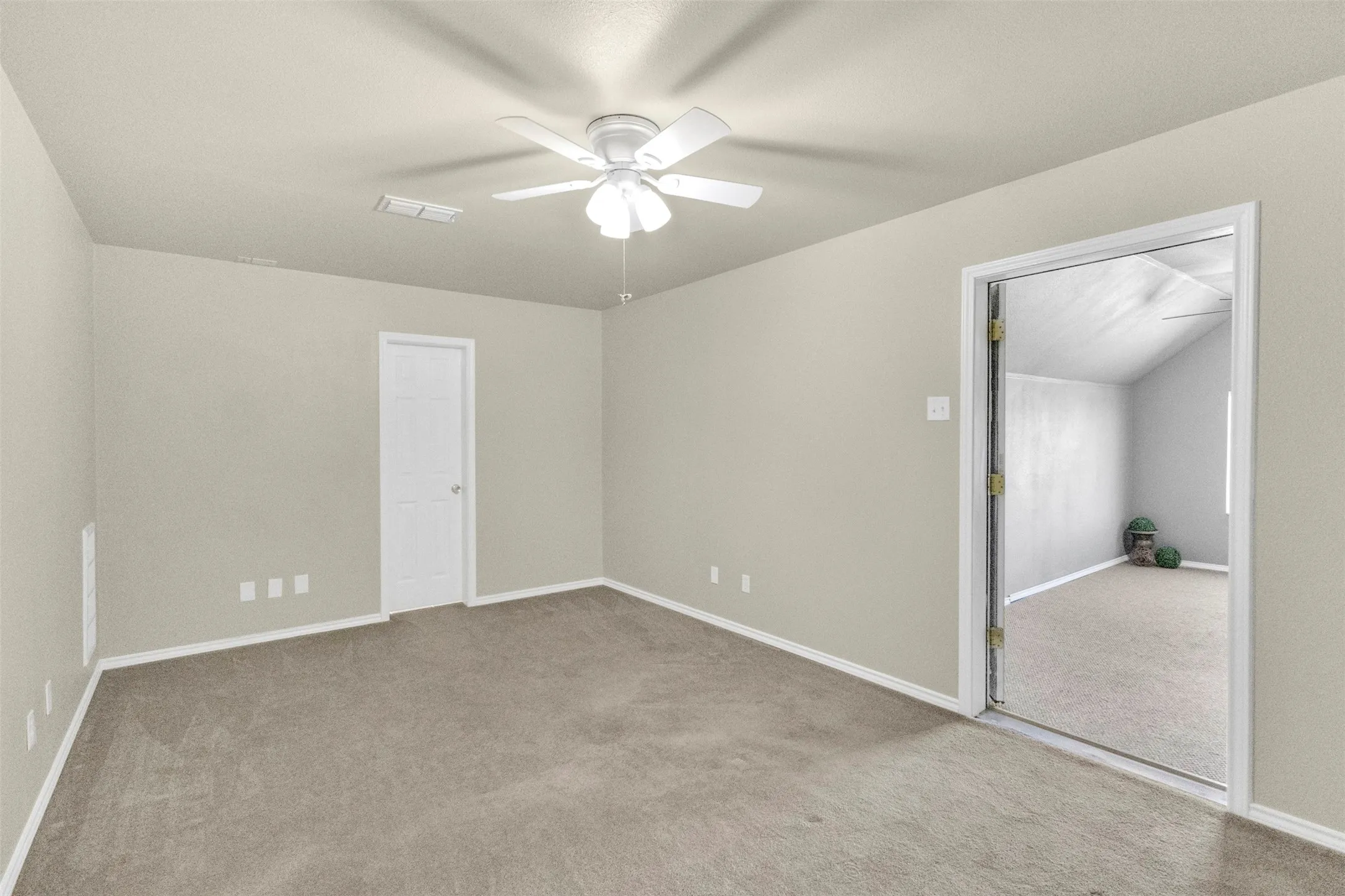 Unfurnished bedroom featuring light colored carpet and ceiling fan
