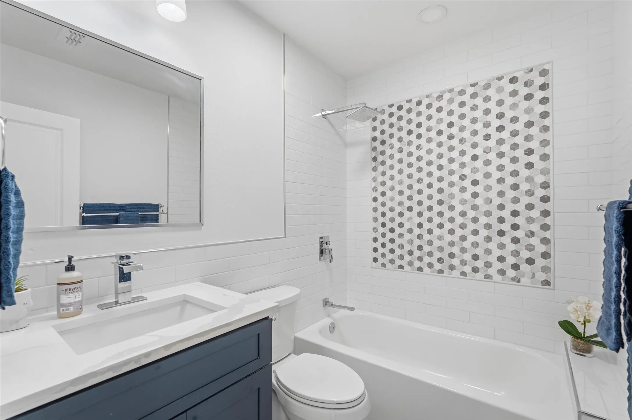 Upgraded bathroom featuring brand new tile and custom cabinetry for a fresh, modern feel.
