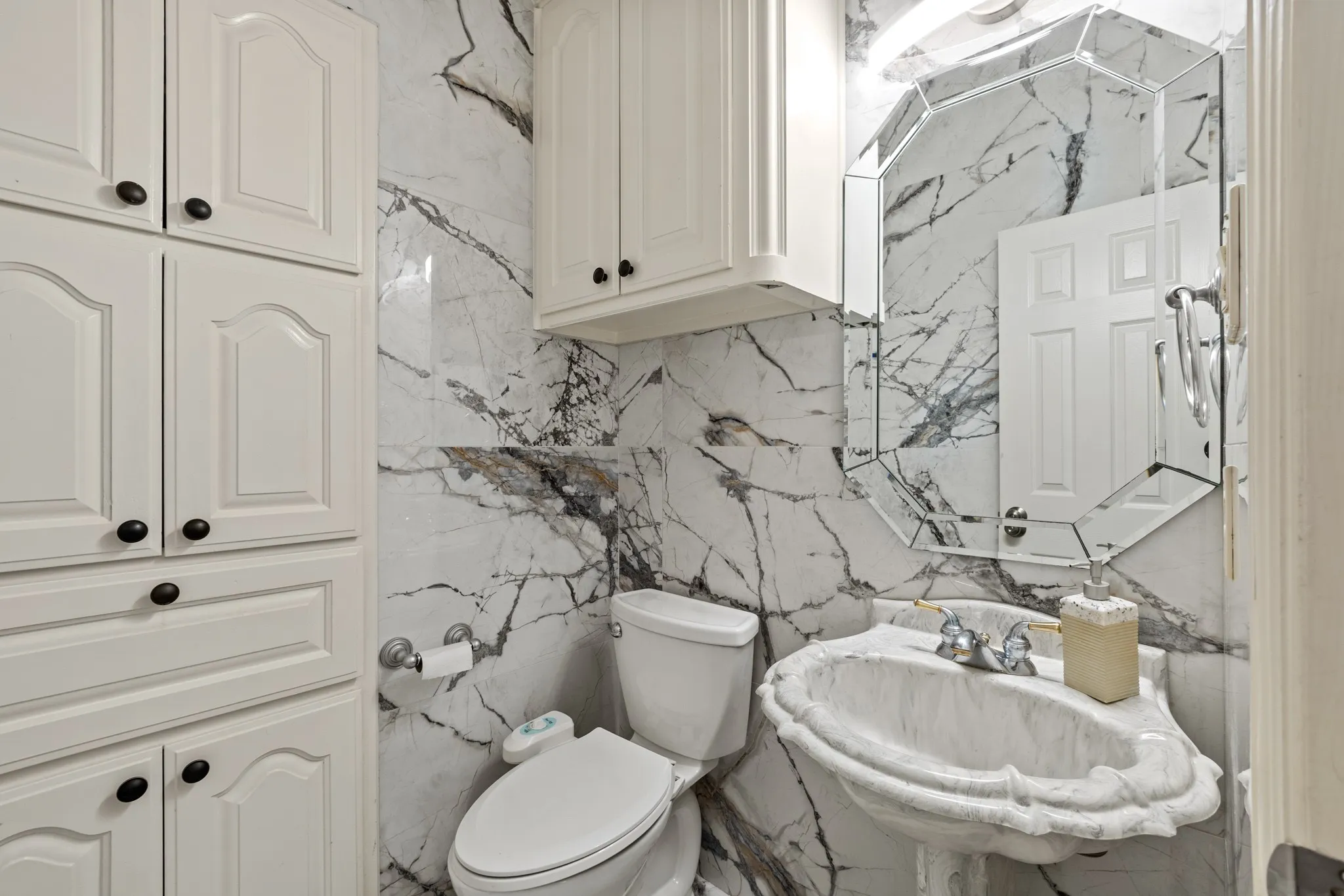 Half Bathroom featuring sink, toilet, and tile walls