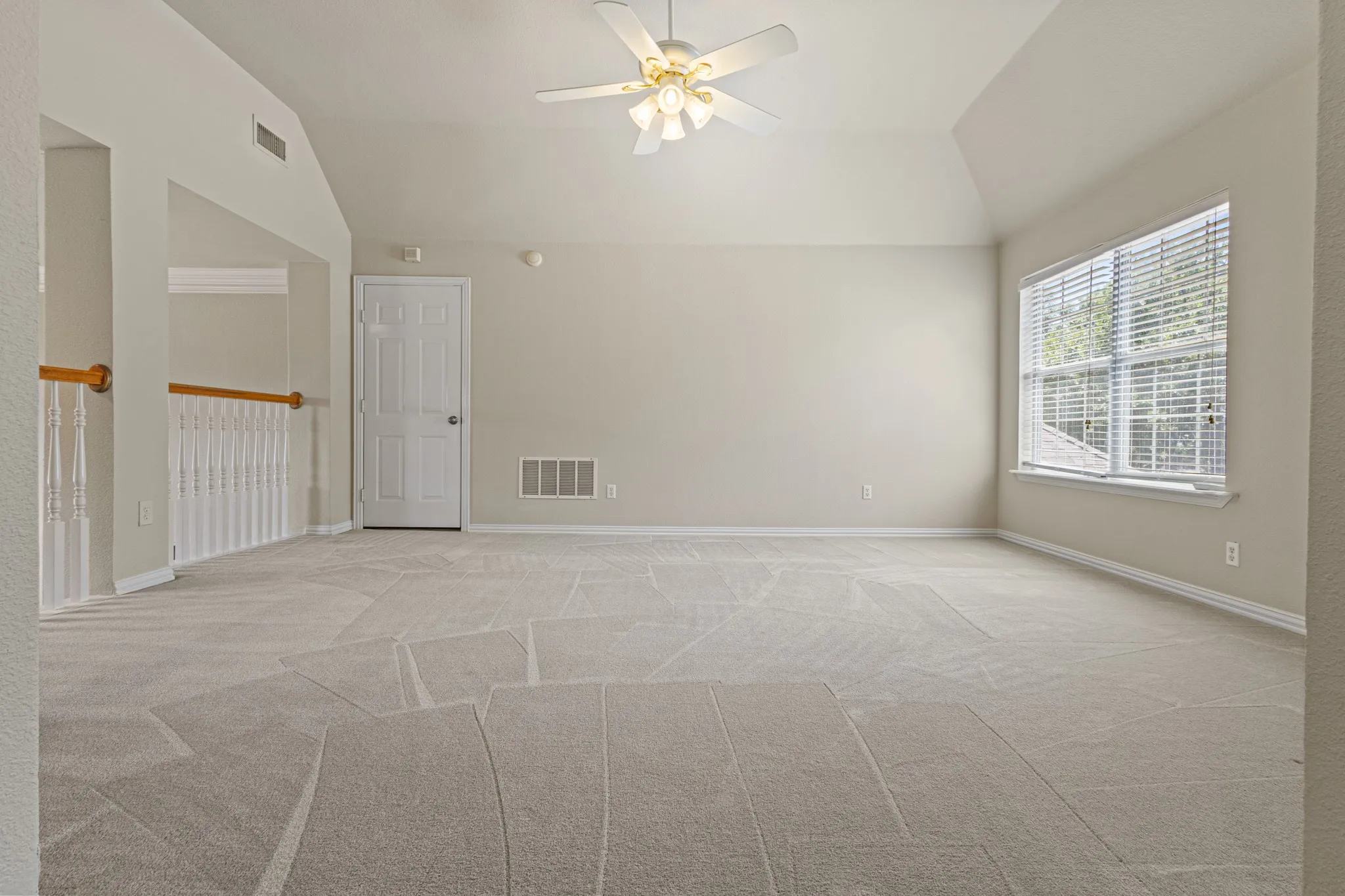 Spare room featuring light carpet, ceiling fan, and lofted ceiling