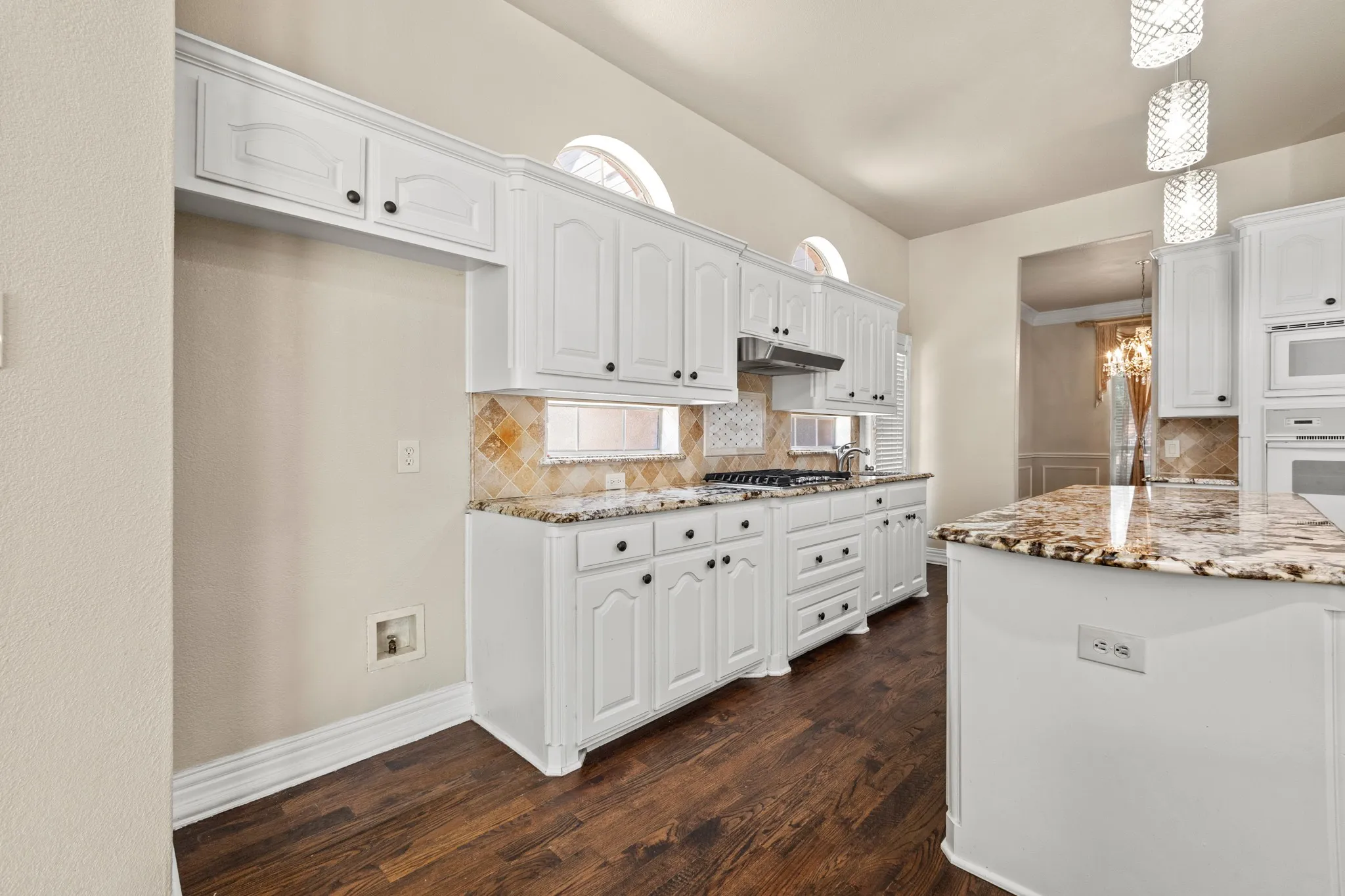 Kitchen featuring backsplash, white cabinets, and dark hardwood / wood-style floors
