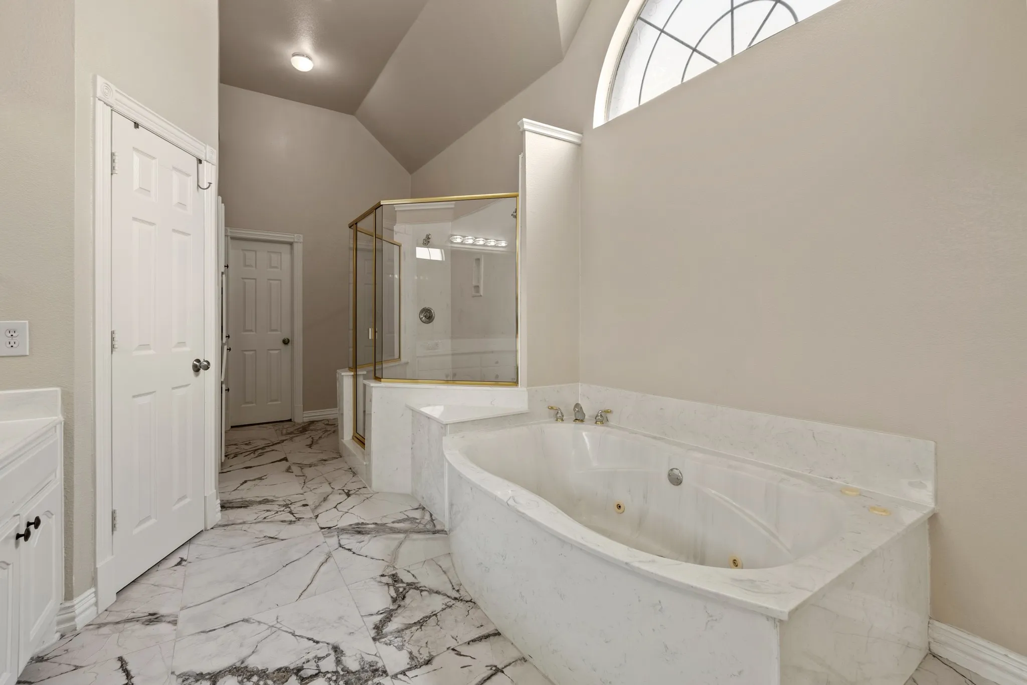 Bathroom featuring shower with separate bathtub, tile flooring, vanity, and lofted ceiling