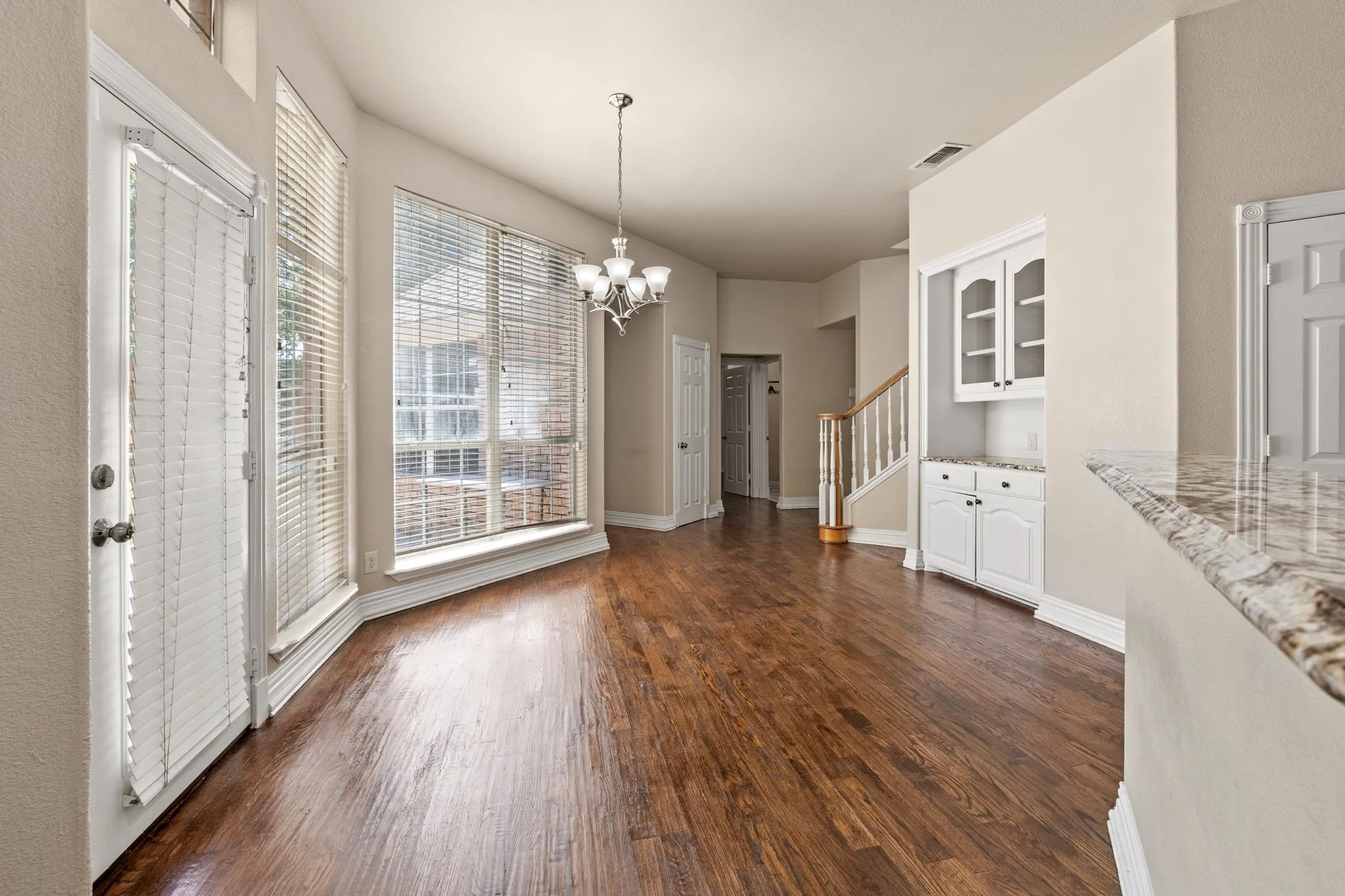 Unfurnished dining area with a chandelier, a wealth of natural light, and dark hardwood / wood-style floors