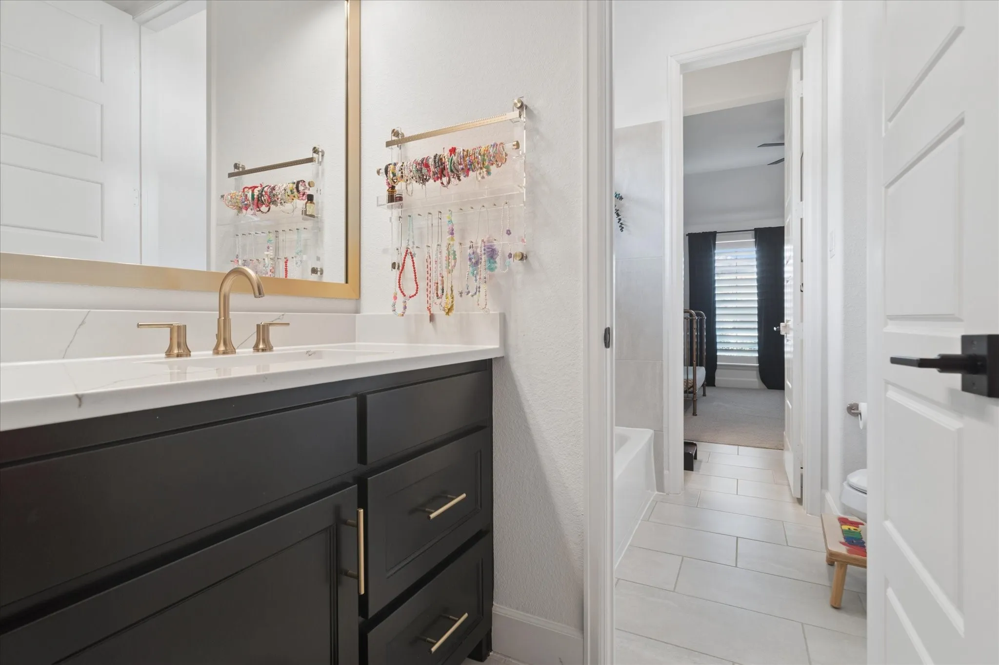 Hollywood Bath between 2 secondary bedrooms offers separate vanities with sinks, shared bathtub, shower and toilet area.