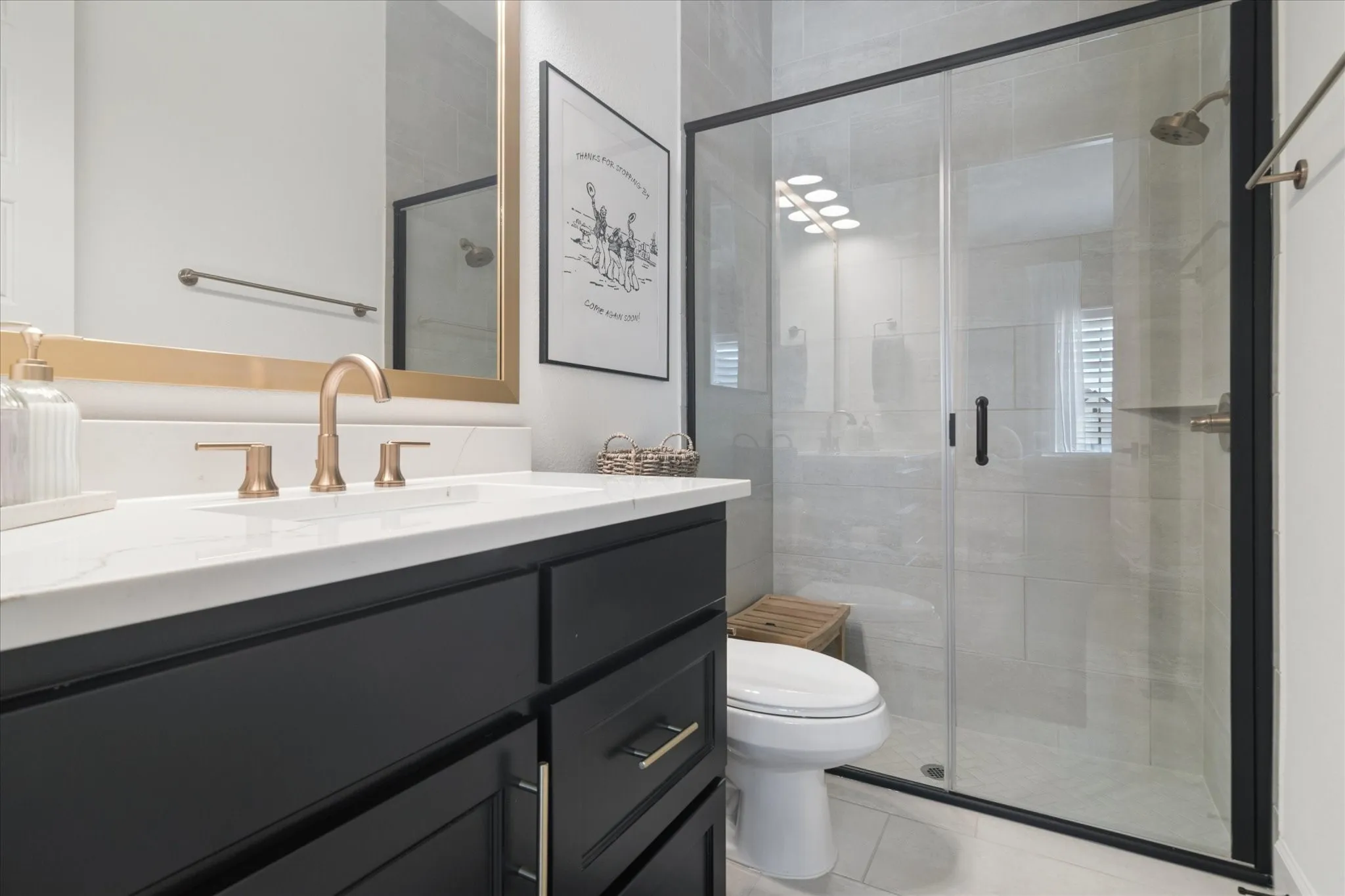 Secondary bathroom, large walk in shower with glass enclosure, quartz countertop.