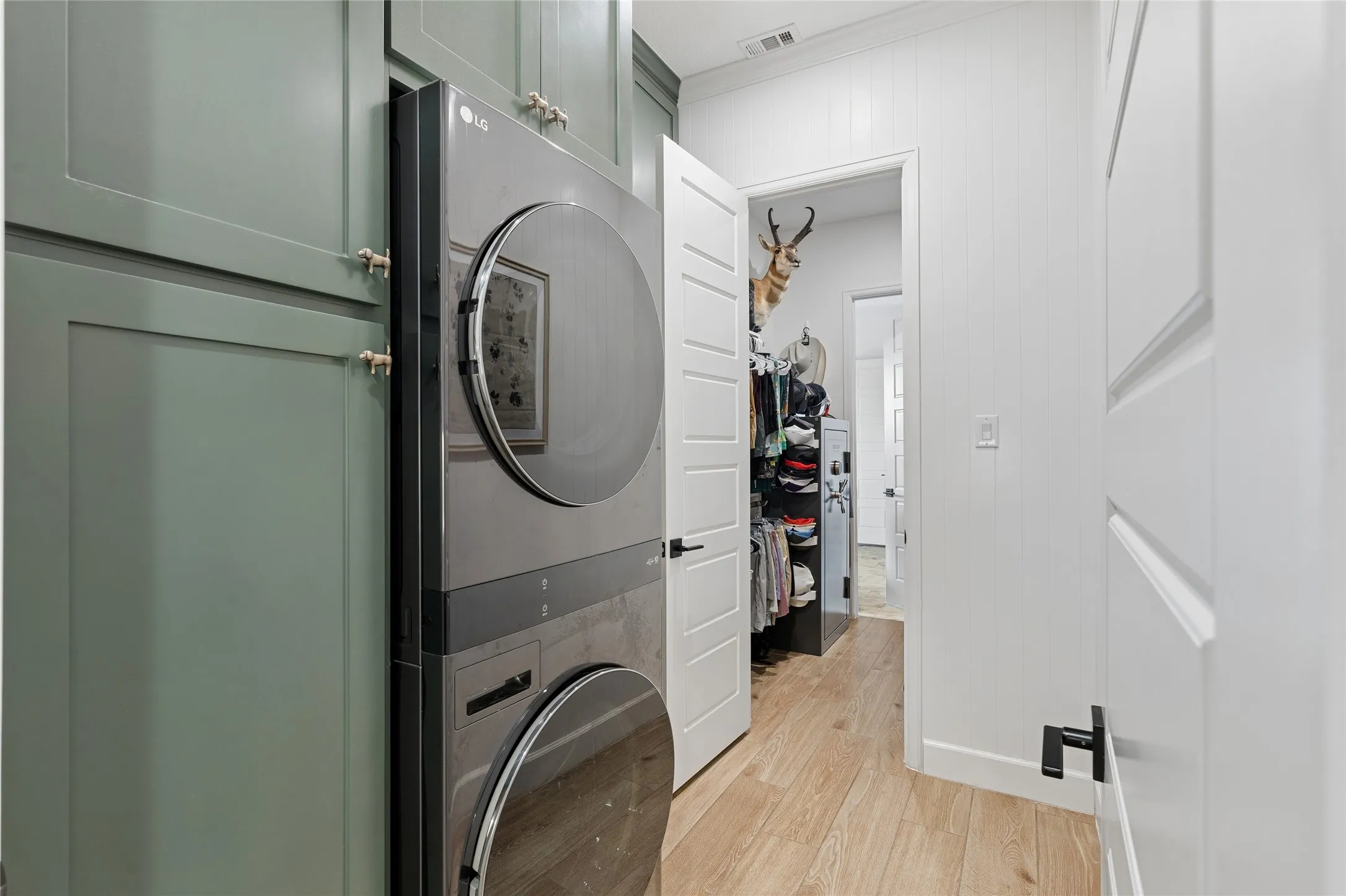 Laundry opens directly into primary closet. Floor to ceiling cabinets, folding table. Opposite door opens to the pantry, kitchen area.