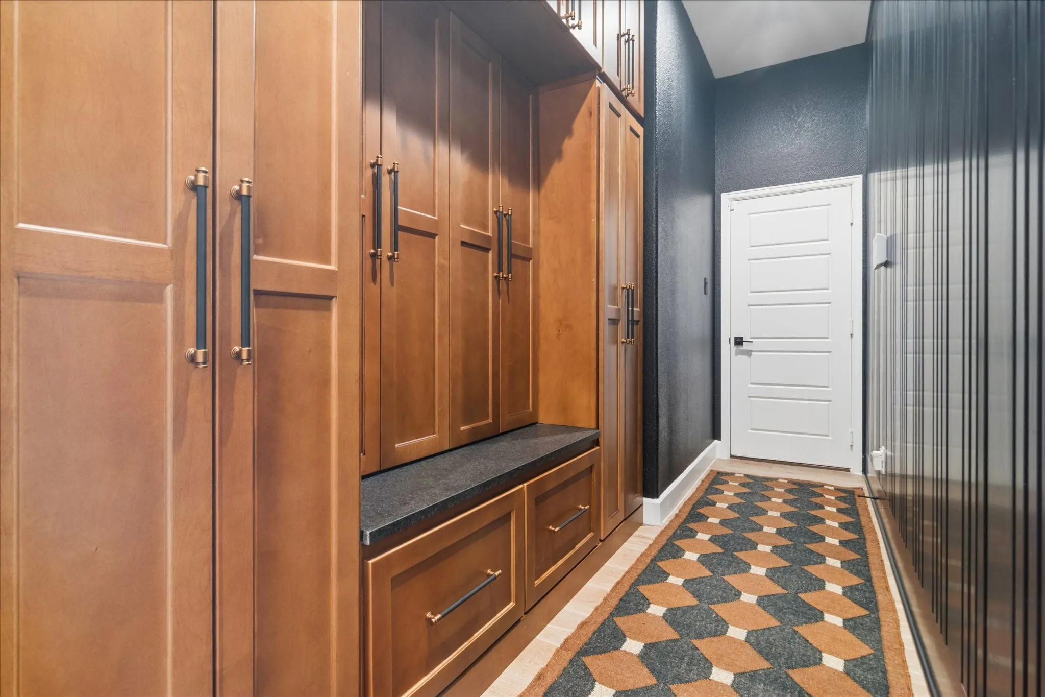 Fabulous mudroom just off of the garage with custom stained cabinetry, marble seating, drawers below, so much storage, even above to the ceiling. Custom accent wall.