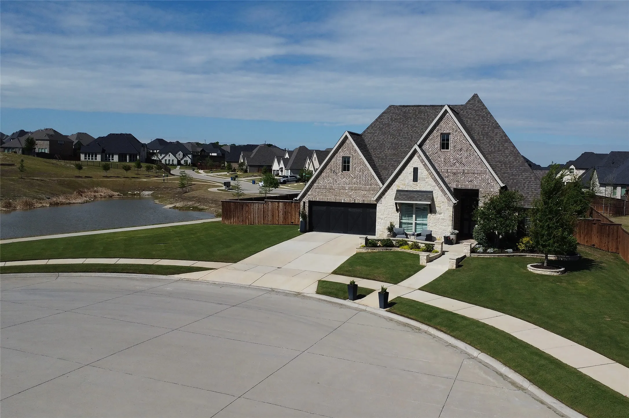 Beautiful curb appeal, meticulously maintained yard. Custom stone work at front porch and walk way. Brick and stone exterior, cul de sac, extra long driveway. Tandem 3 car garage. Home sits at the end of the cul de sac next to neighborhood pond for added privacy.