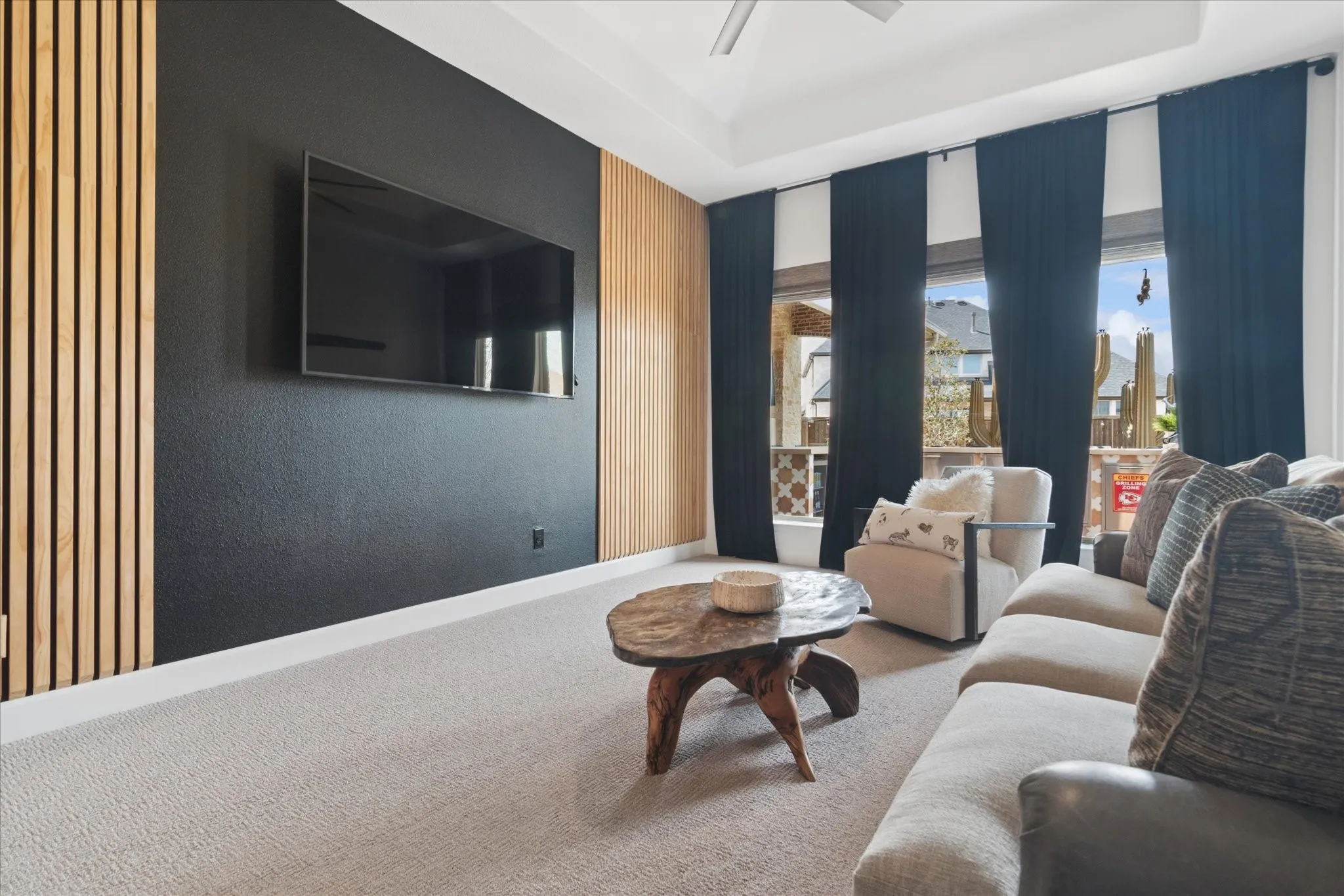 Wall of windows into the backyard. Custom accent wall, tray ceiling.