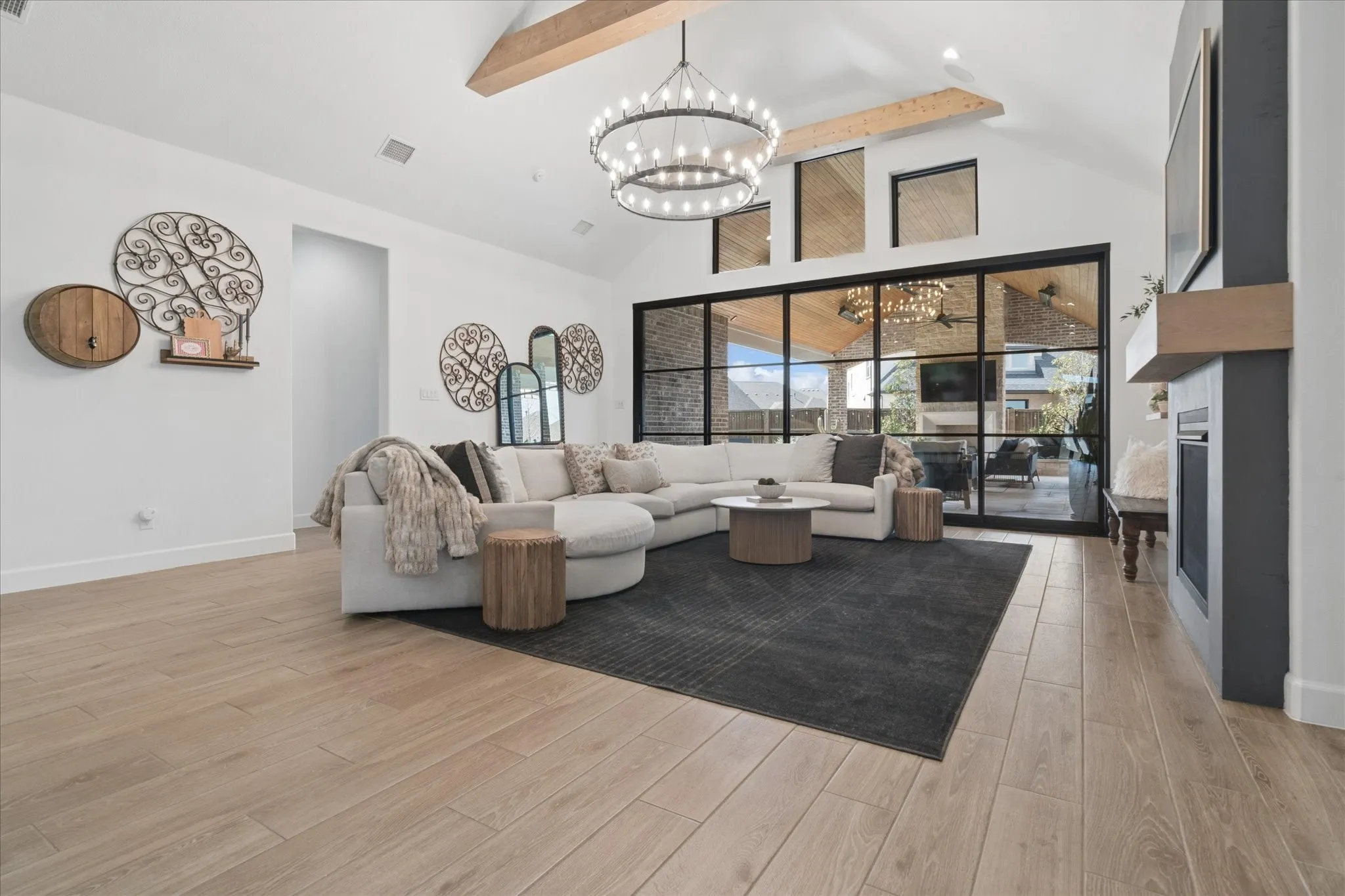 Wall of windows stack open to the right panel to bring the outdoor living area in, glass and steel finish. Transom windows above bring the outside in. Vaulted ceiling with stained beams. Renovated fireplace, surround and stained mantle.