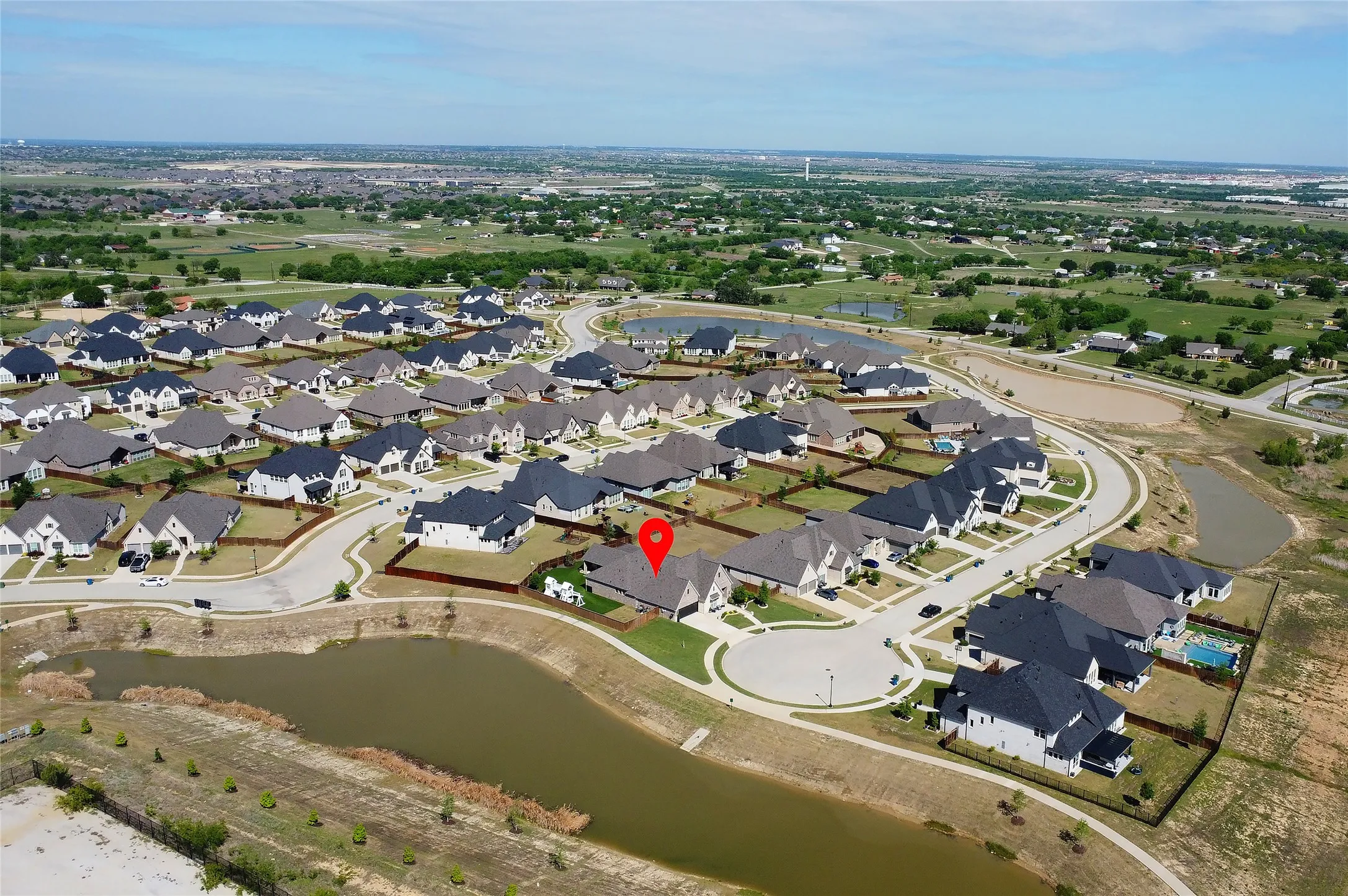 Aerial view of cul de sac and neighborhood pond next to the home.