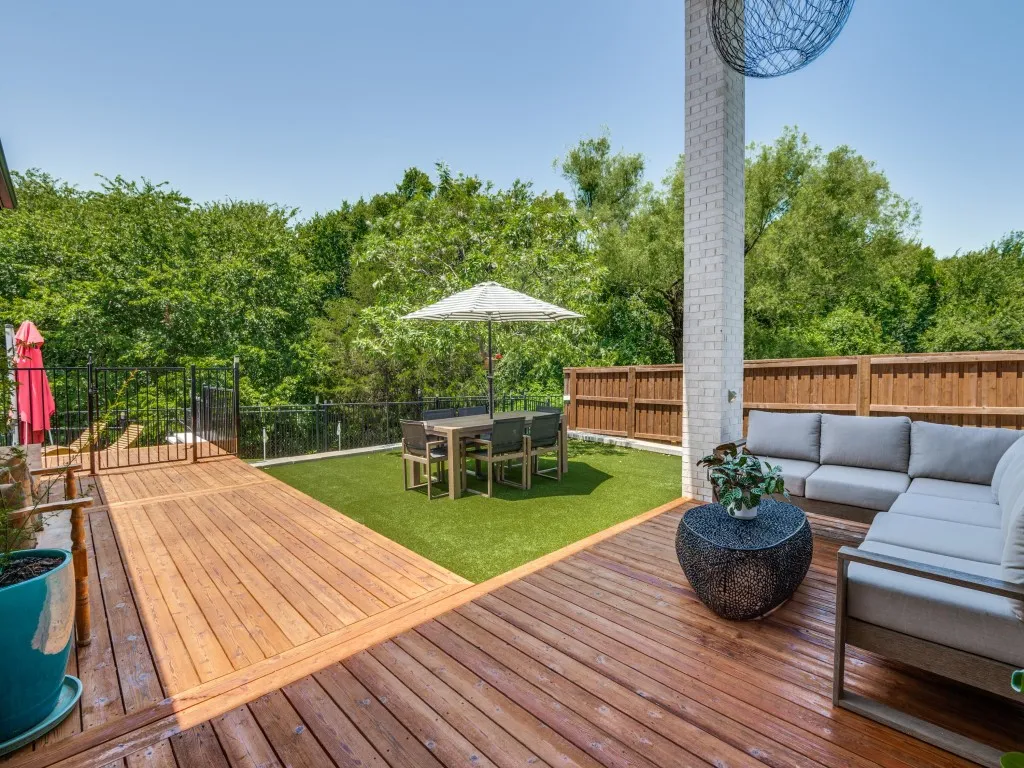 Wooden terrace featuring outdoor lounge area, a fenced backyard, outdoor dining area, and view of scattered trees