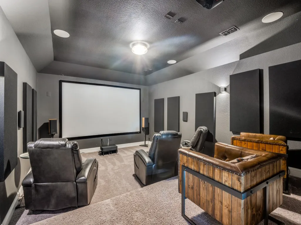 Carpeted home theater featuring a raised ceiling, lofted ceiling, and a textured ceiling
