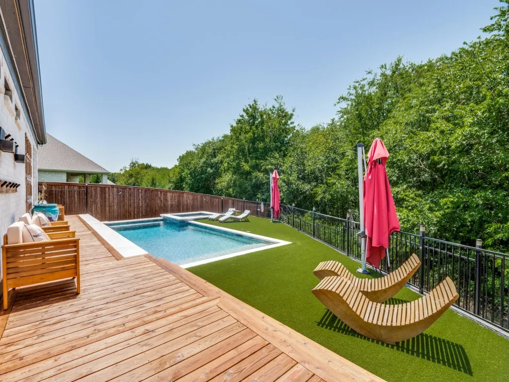 View of swimming pool with a fenced backyard, a deck, and a pool with connected hot tub