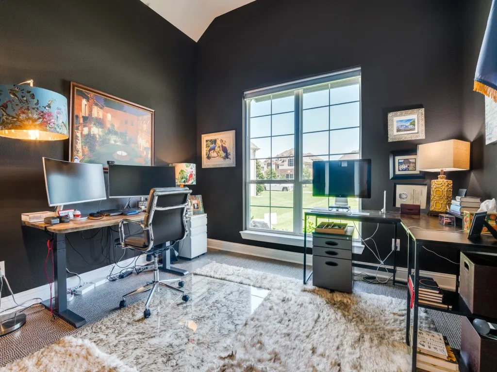 Carpeted office space with plenty of natural light and vaulted ceiling