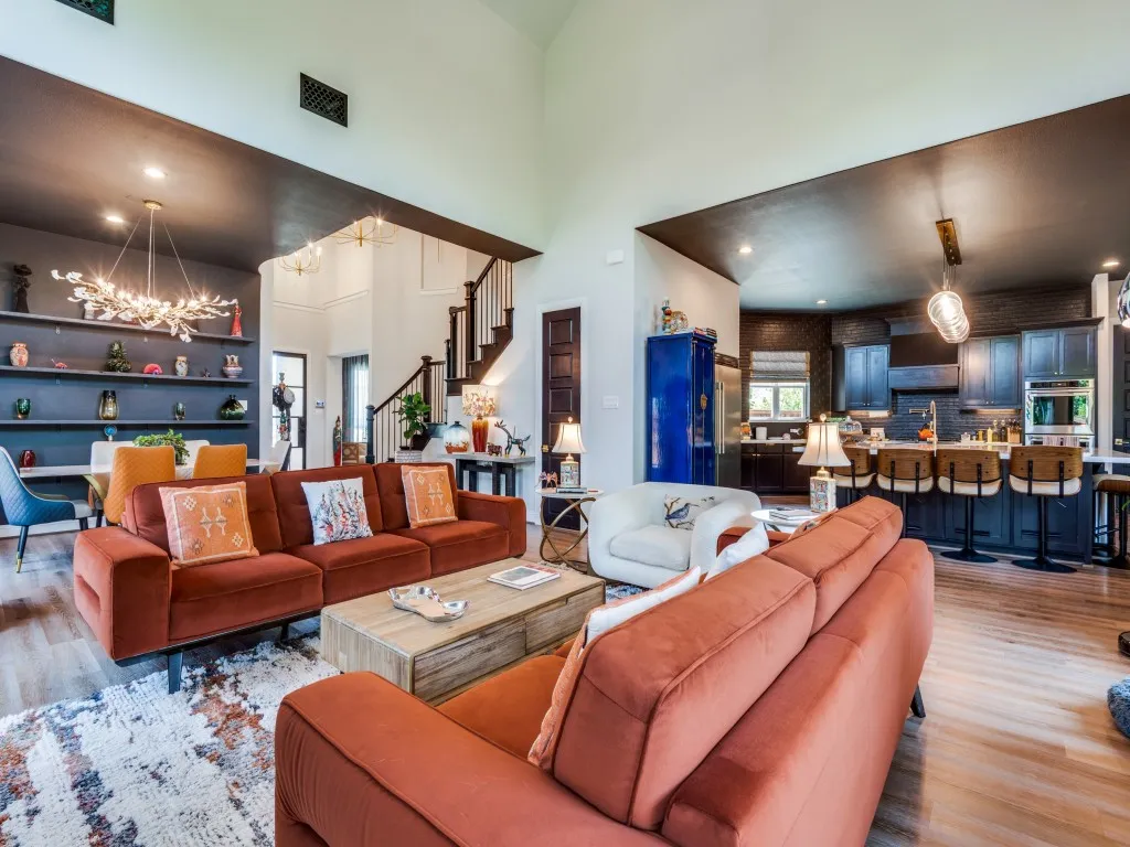Living area featuring a chandelier, wood finished floors, stairs, and a towering ceiling