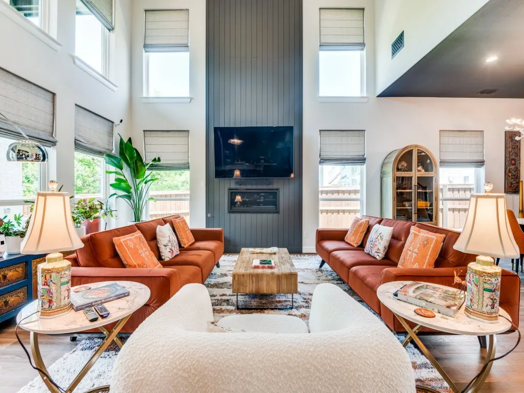 Living area featuring a towering ceiling, wood finished floors, plenty of natural light, and a fireplace