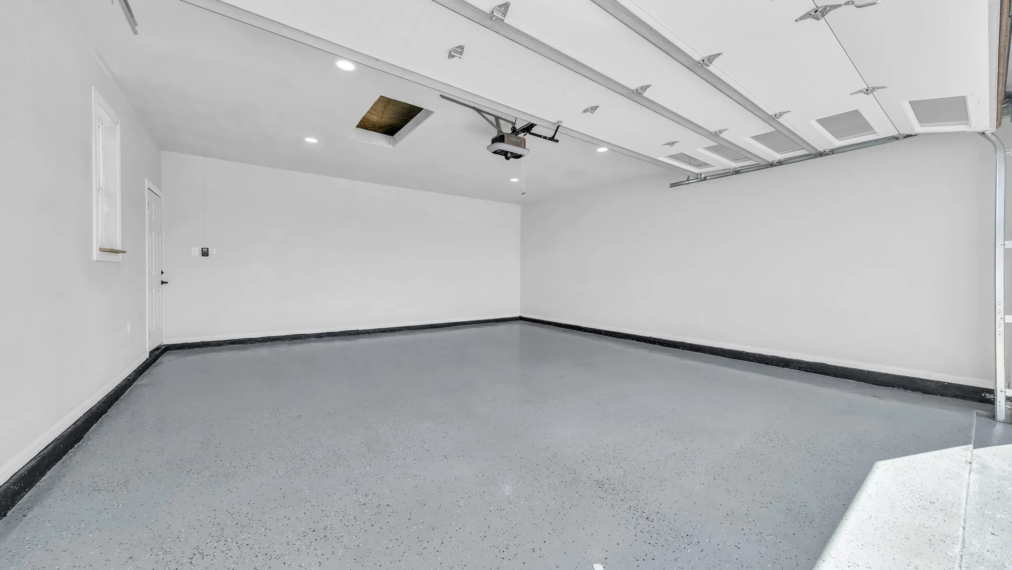 Spacious garage with epoxy flooring.
