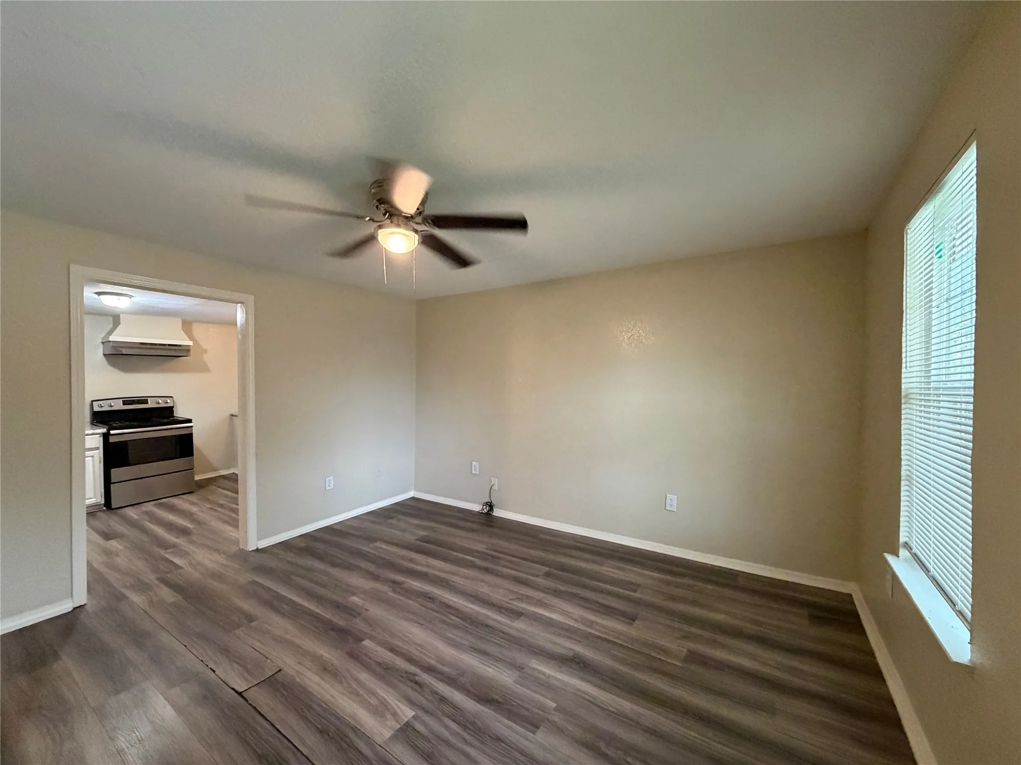 Spare room featuring dark wood-style flooring and a ceiling fan