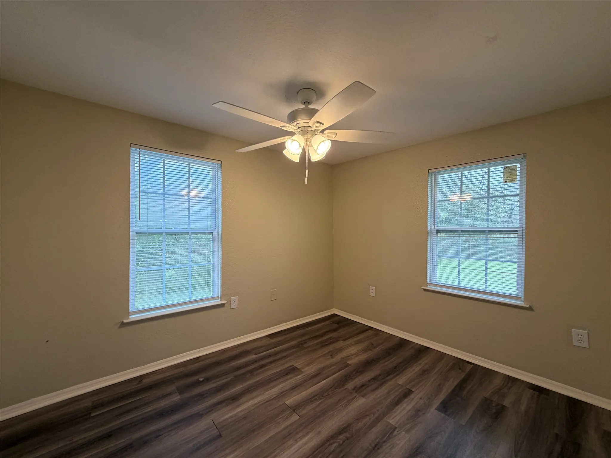 Unfurnished room with dark wood-style flooring and ceiling fan