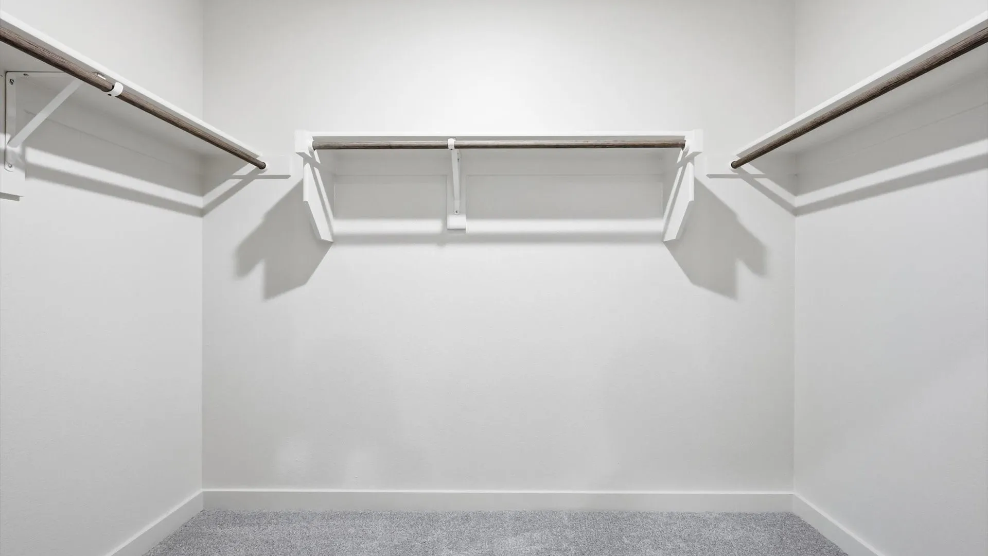 Spacious closet featuring light gray carpeting, crisp white walls, white trim, and multiple clothing rods for​​‌​​​​‌​​‌‌​‌‌​​​‌‌​‌​‌​‌​​​‌​​ organization