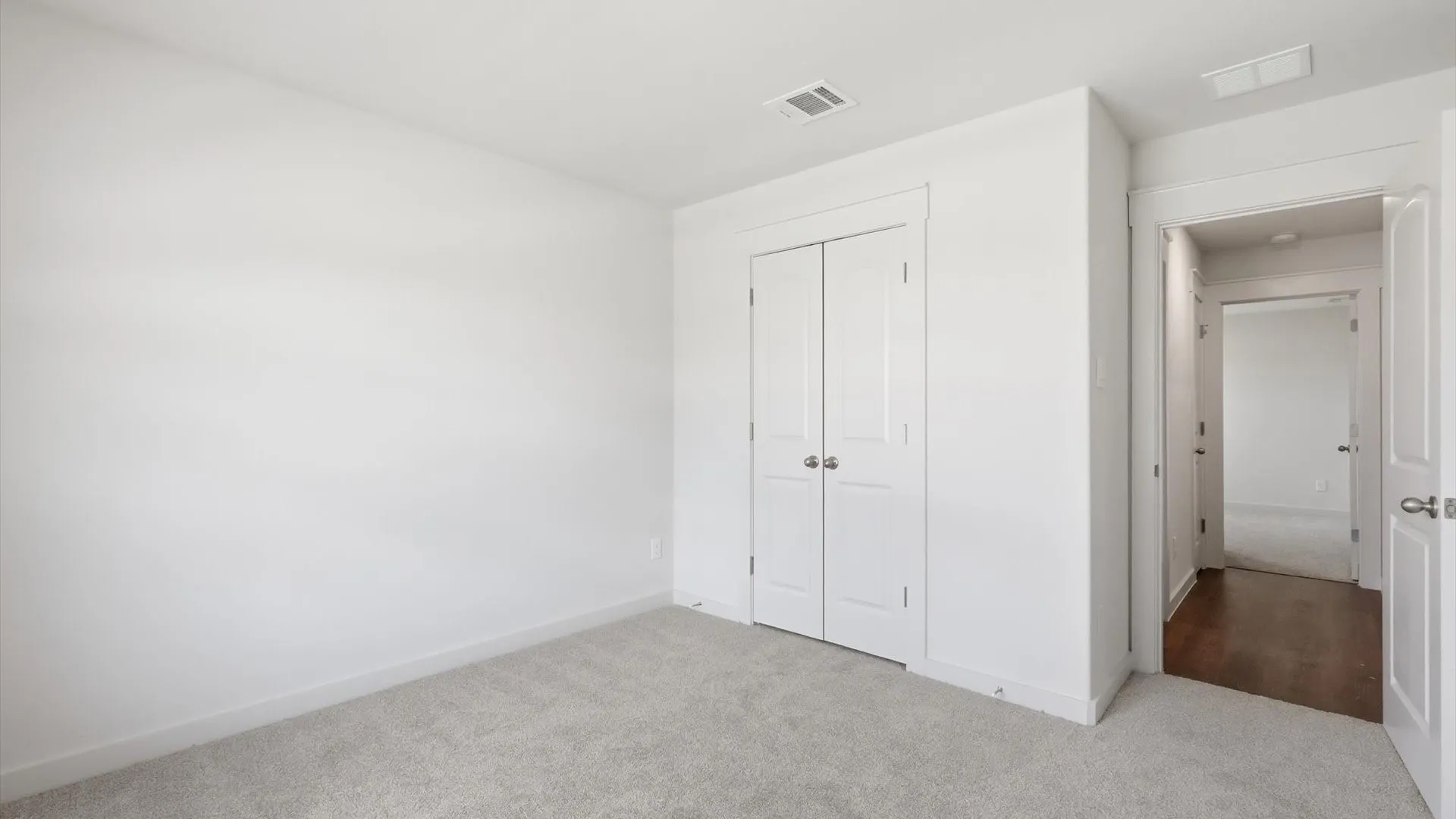 Bright room with light gray carpet flooring and white painted walls