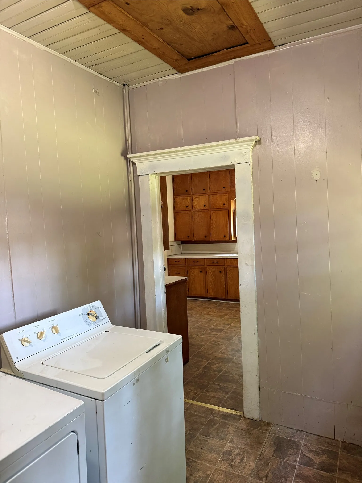 Utility area featuring light-toned paneling and a visible attic access panel