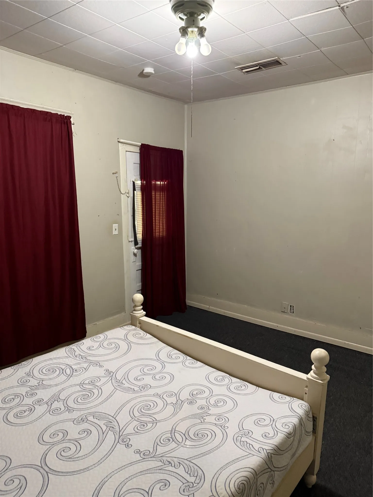 Room featuring carpet flooring and a drop ceiling