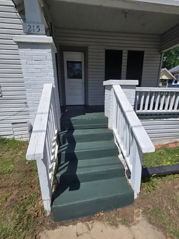 Front entrance featuring painted steps and white wood railings