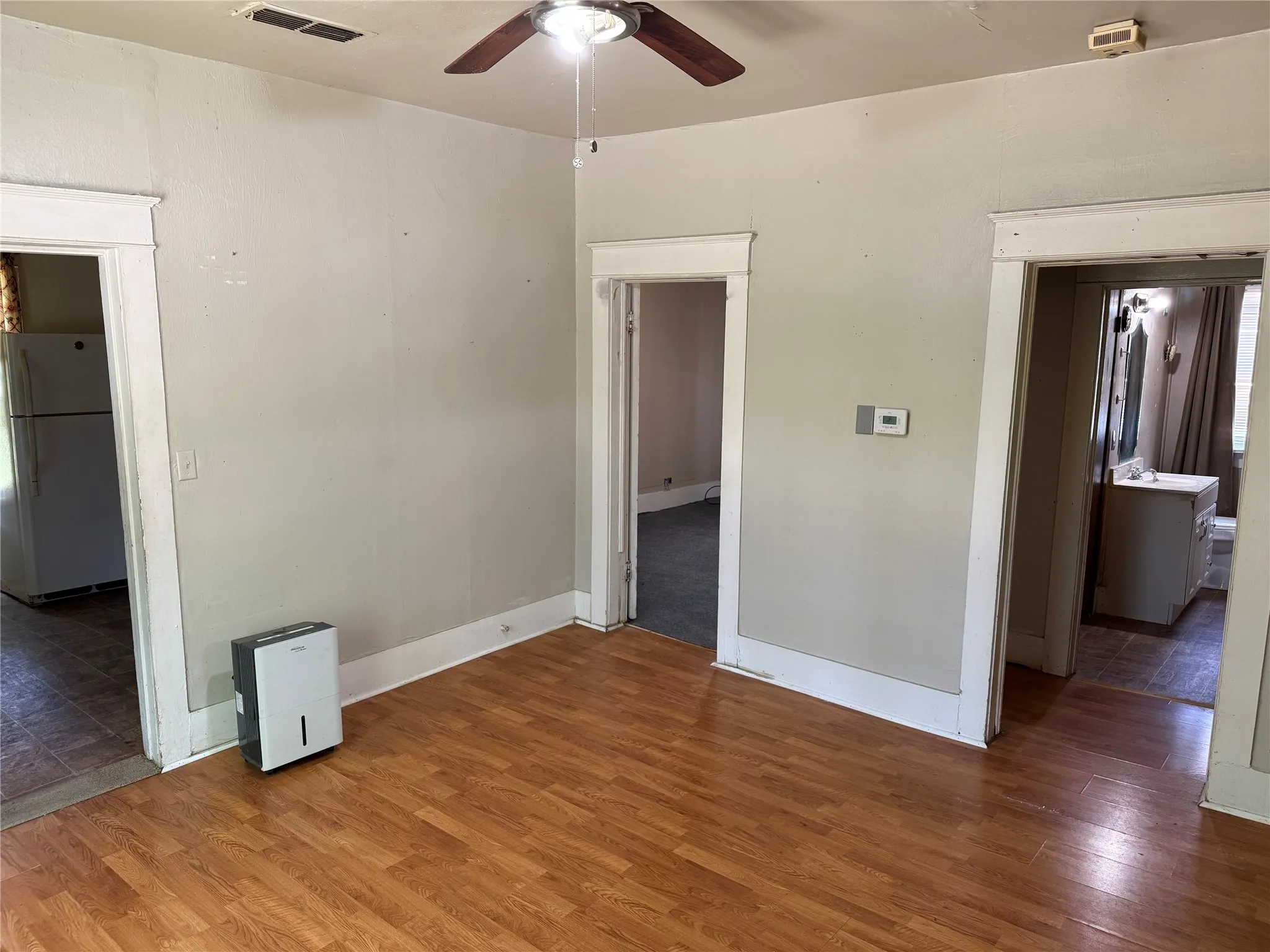 Room featuring wood-finish flooring, light neutral wall paint, and white trim