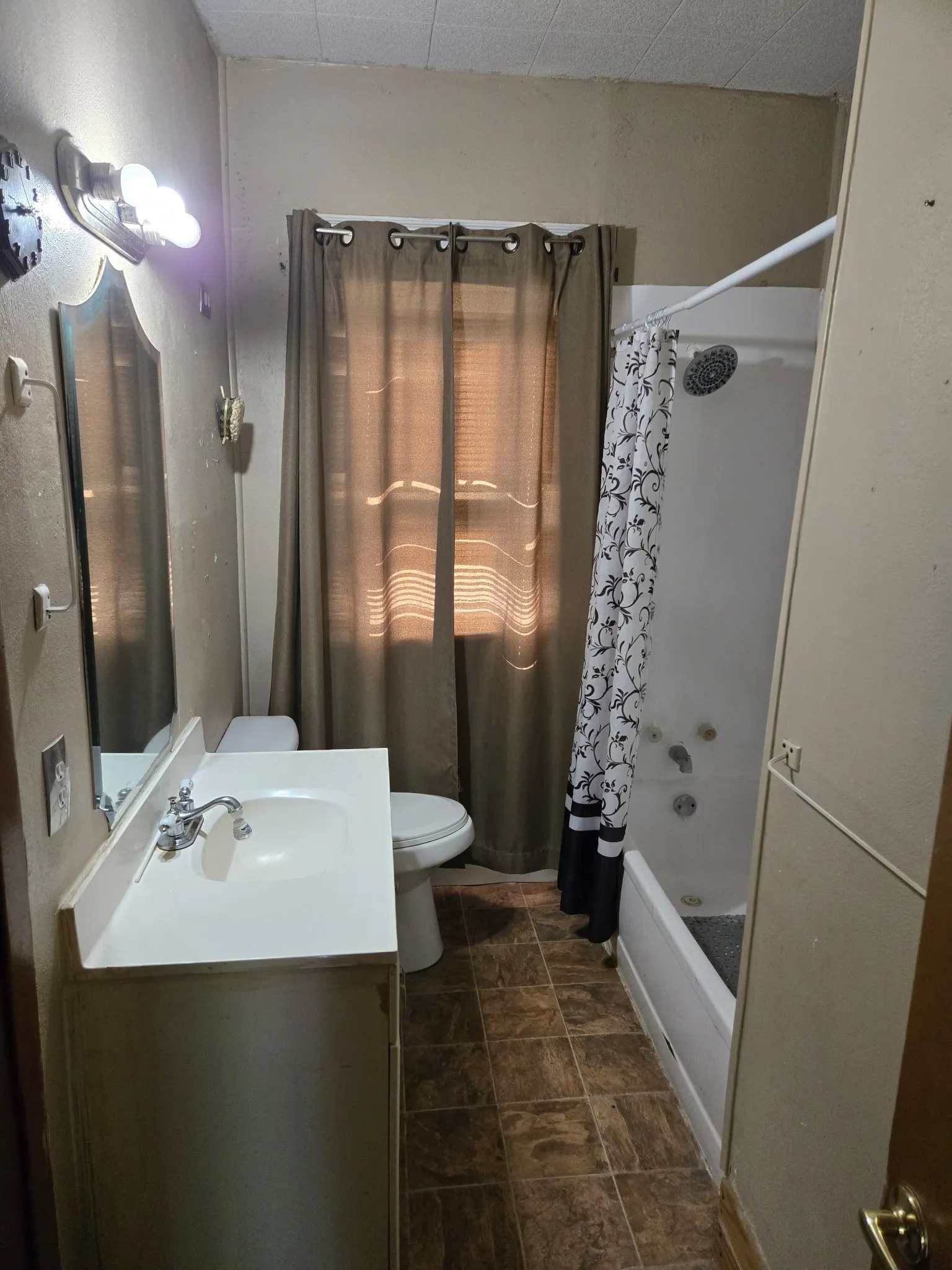 Bathroom featuring a vanity with an integrated sink, a toilet, and a shower-tub combination