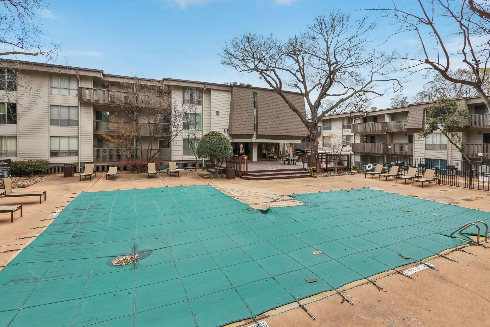 Community pool with a wooden deck and a patio area