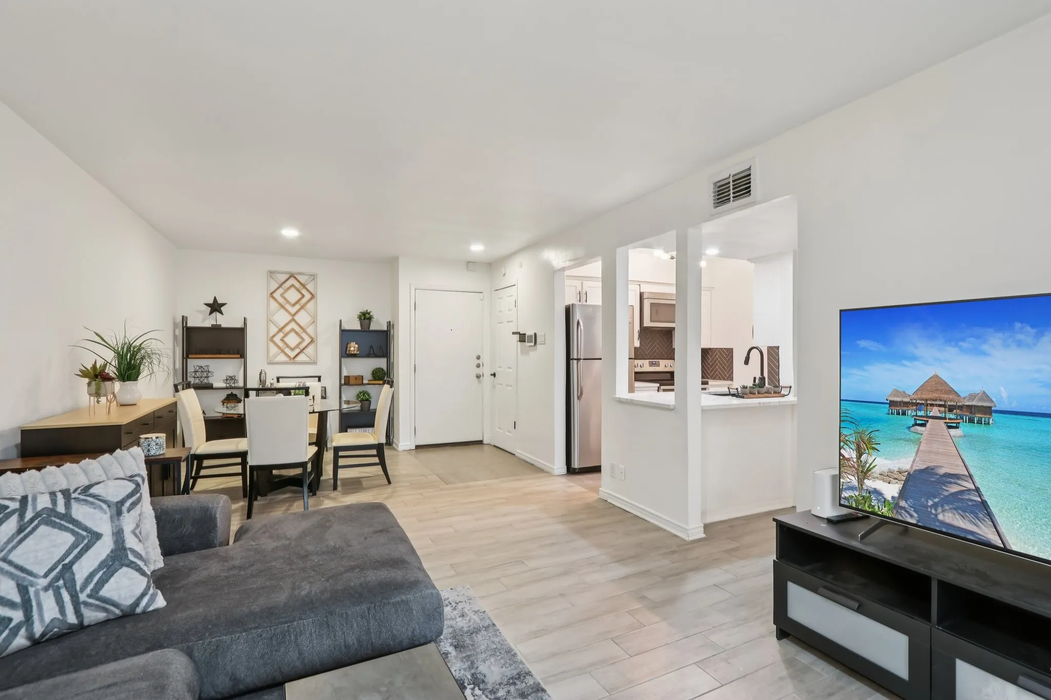 Living area featuring light wood-style tile flooring and recessed lighting