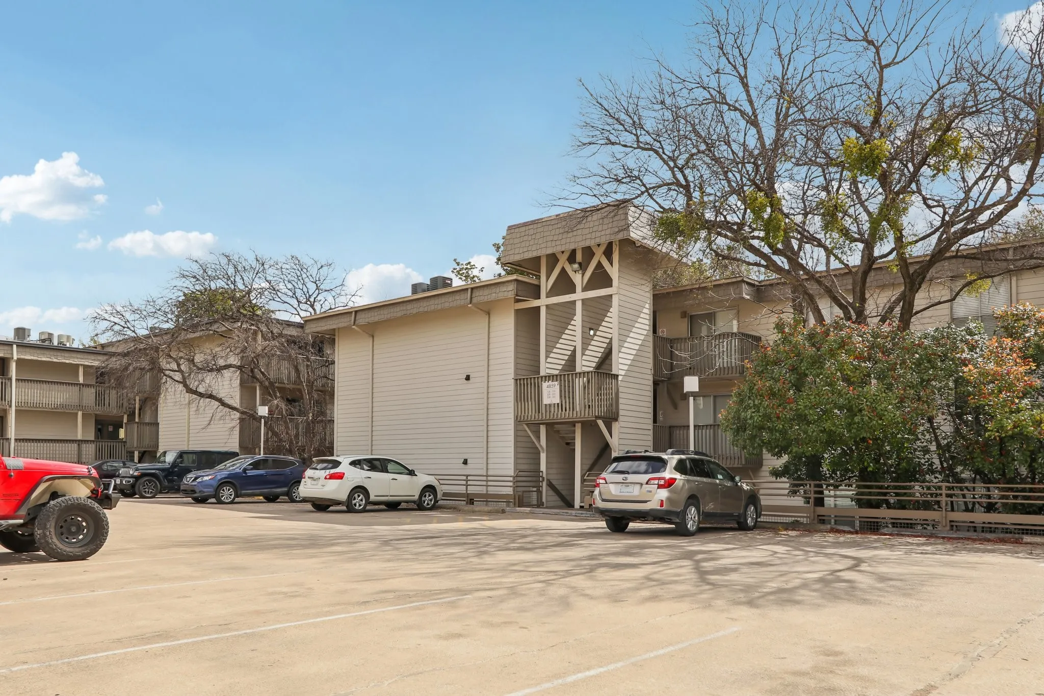 View of apartment building / complex featuring uncovered parking