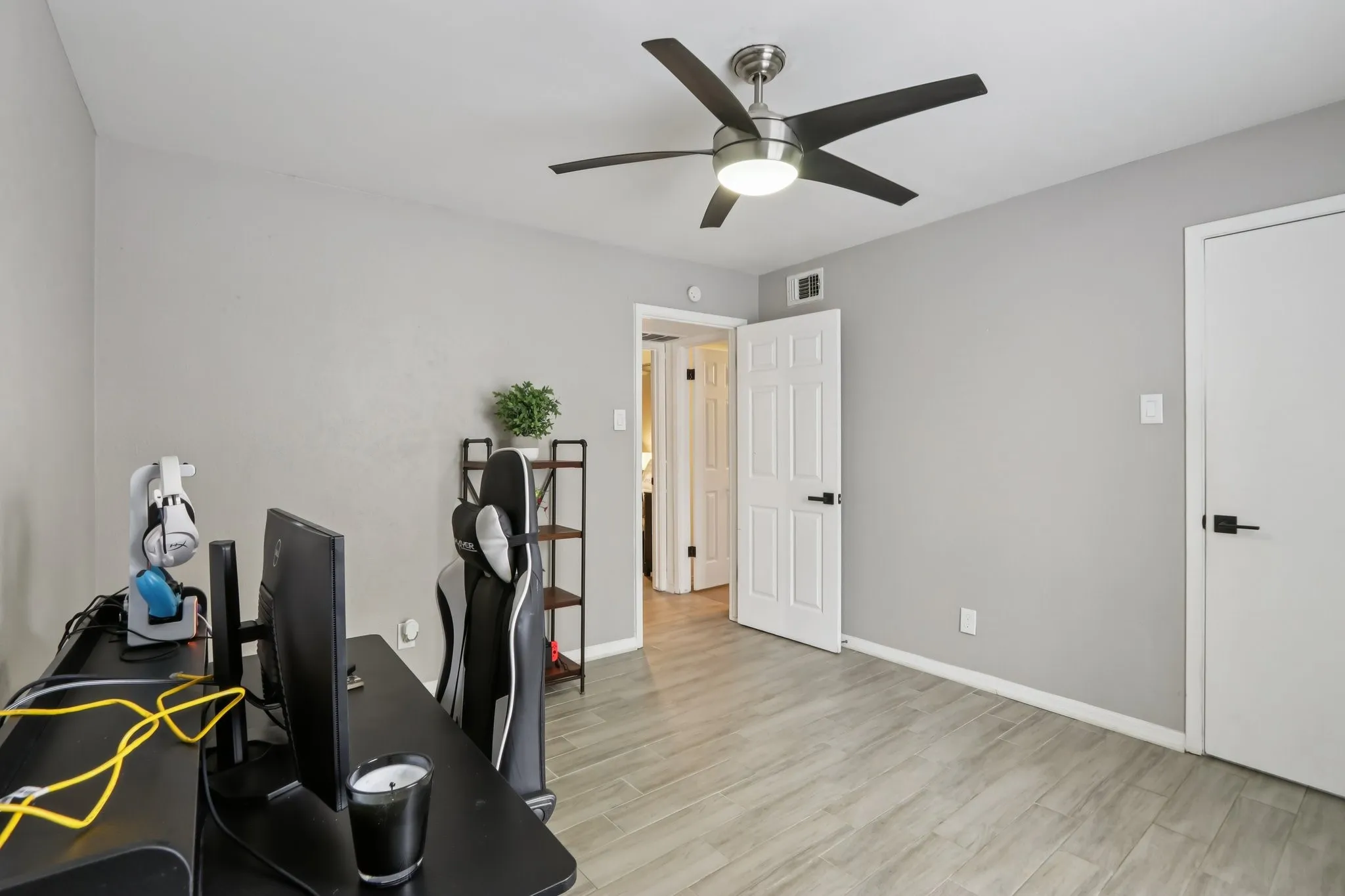 Office space with light wood-style floors and ceiling fan