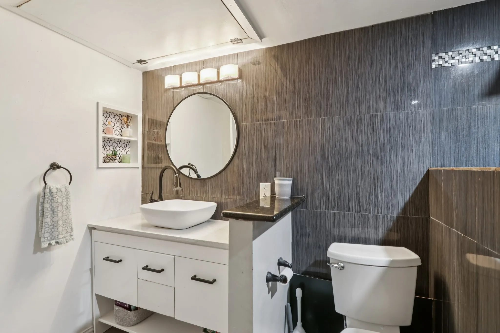 Half bathroom with vanity and tile walls