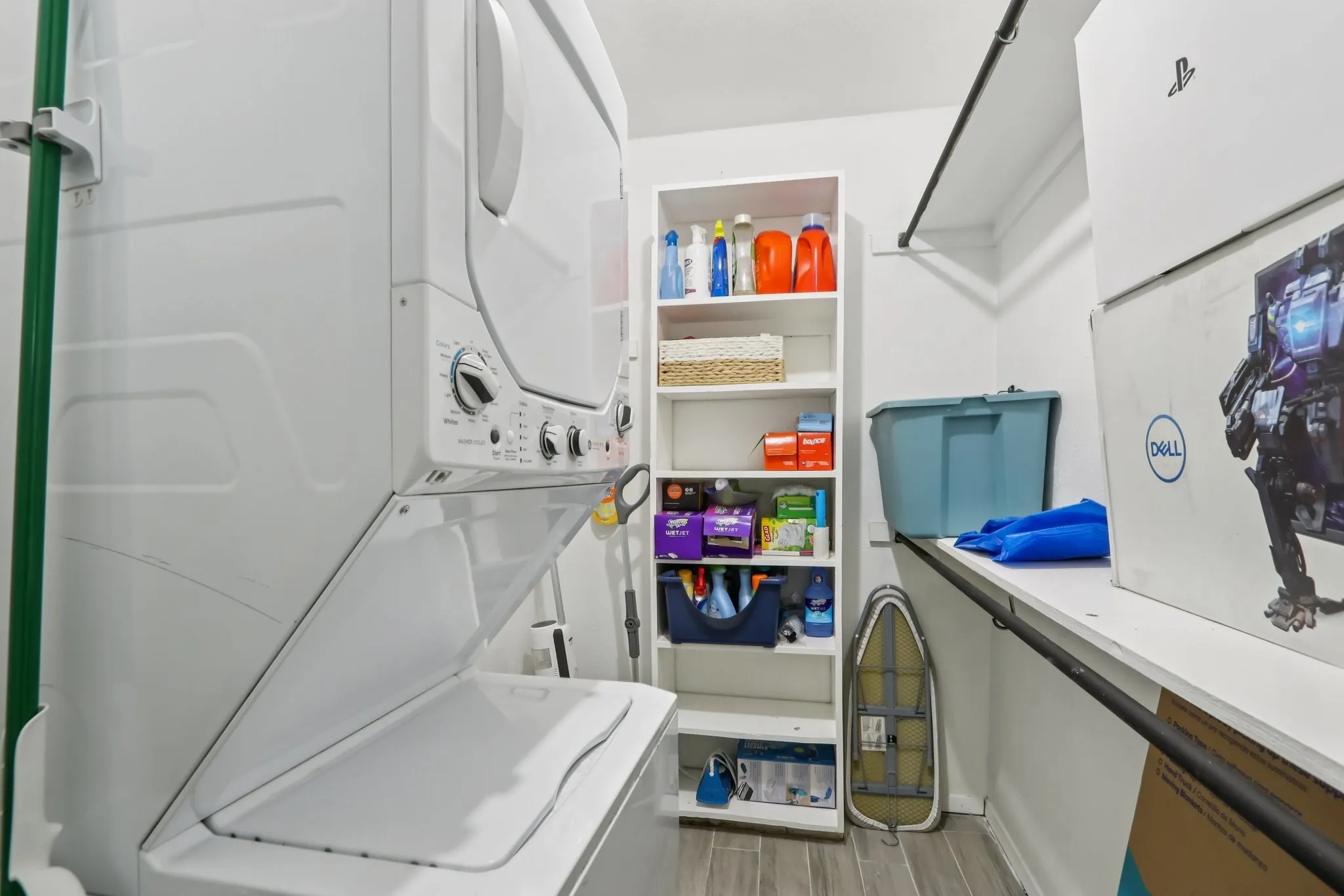 Laundry room with stacked washer / drying machine and light wood-style flooring
