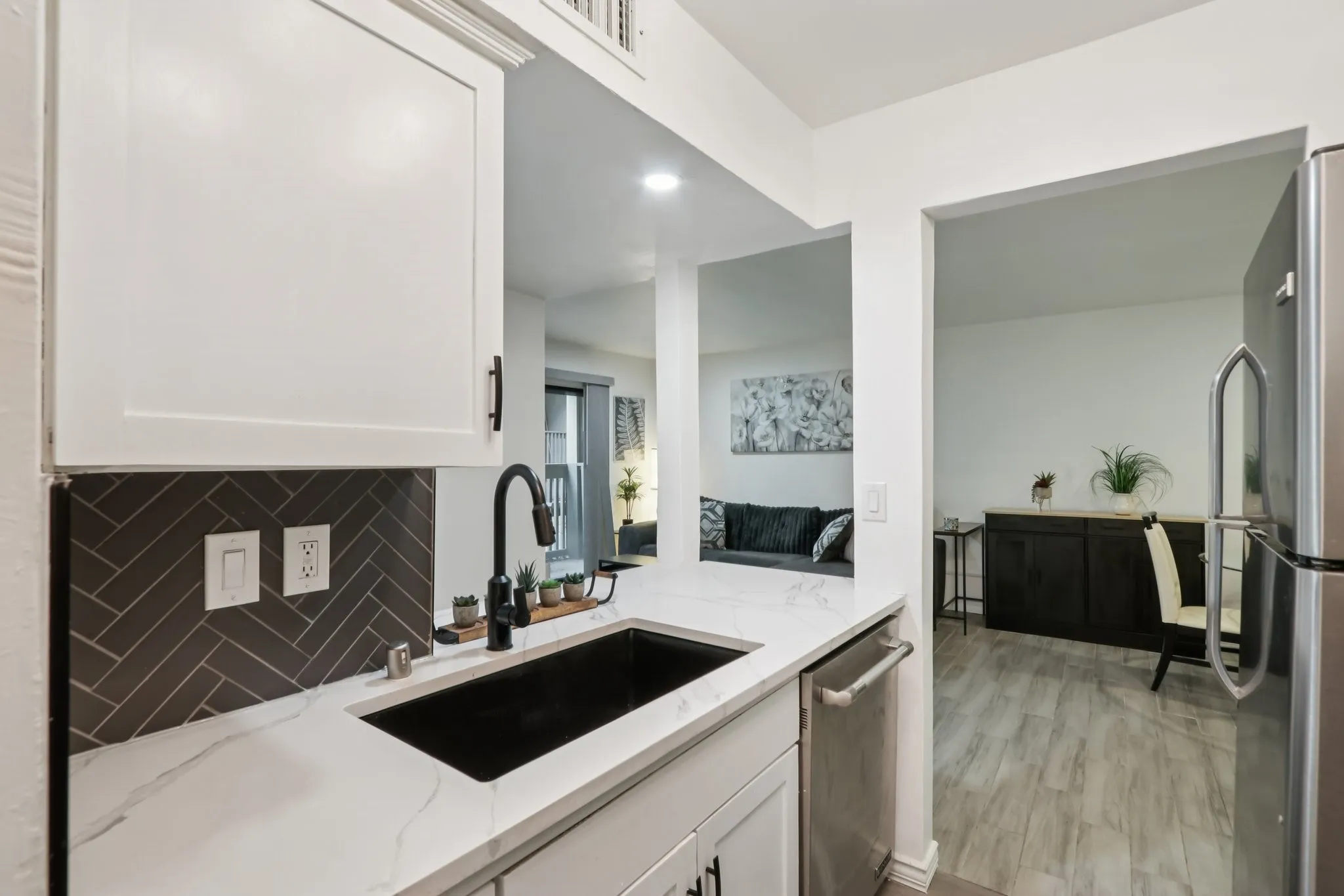 Kitchen featuring stainless steel appliances, light stone countertops, white cabinets, and recessed lighting