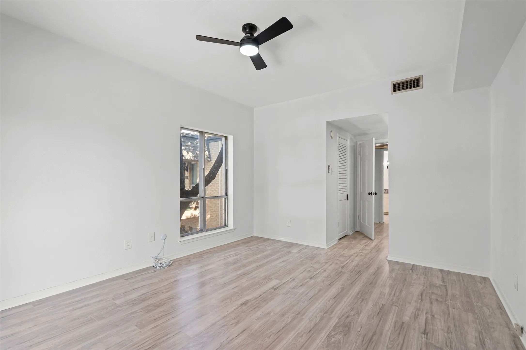 Bedroom with ceiling fan and new LVP flooring.