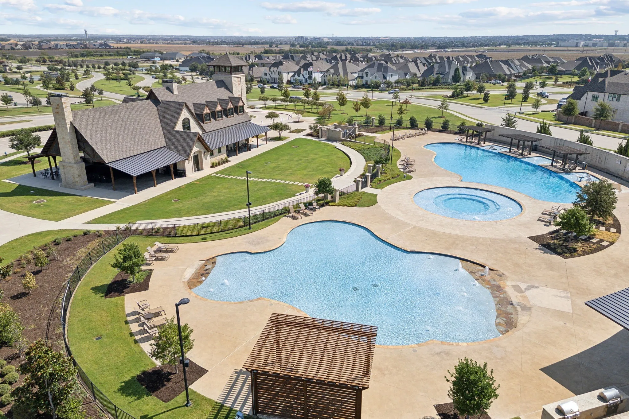 Multi-pool complex with an integrated spa, surrounded by expansive concrete decking