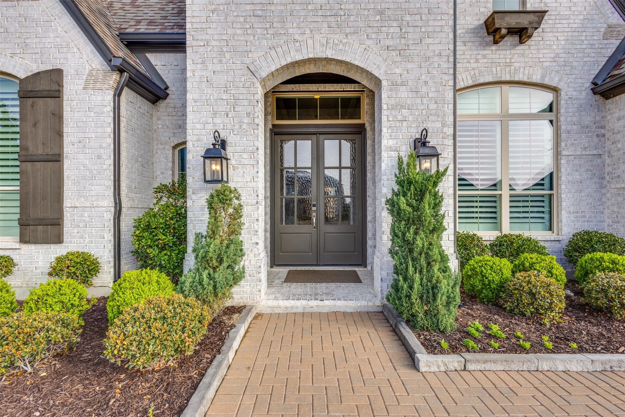 View of exterior entry featuring brick siding and french doors