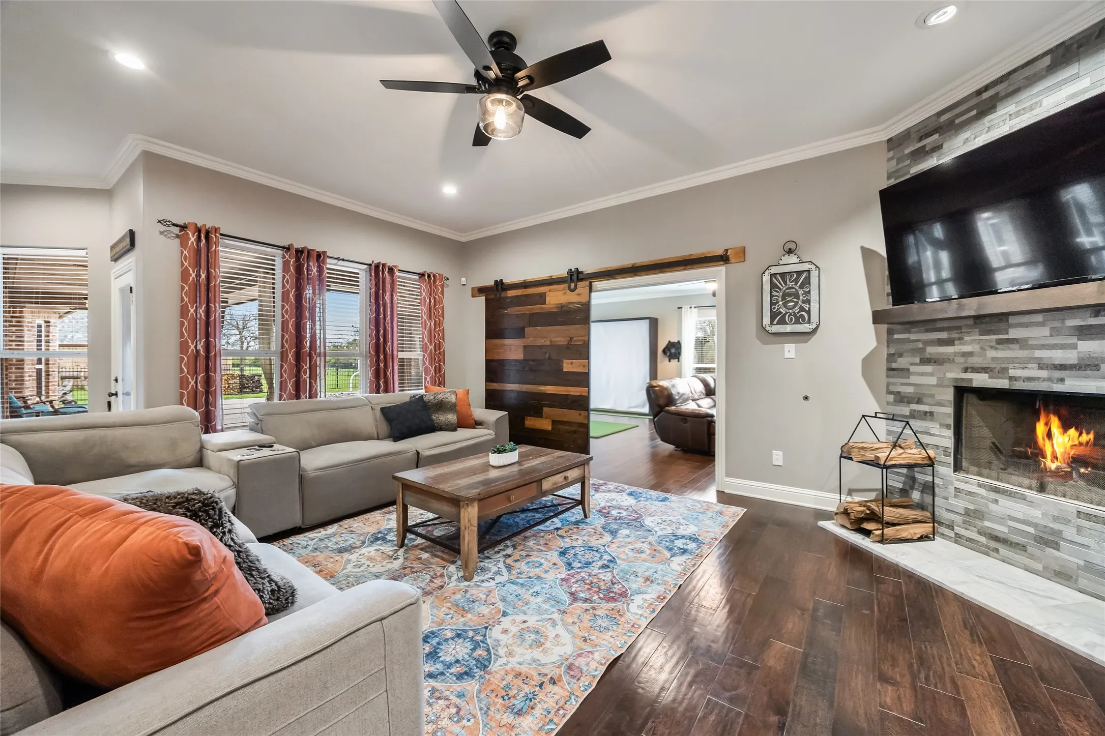 Expansive living room leading to game room through barn door.