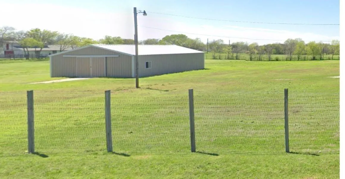 View of green lawn featuring an outbuilding, an outdoor structure, and a rural view