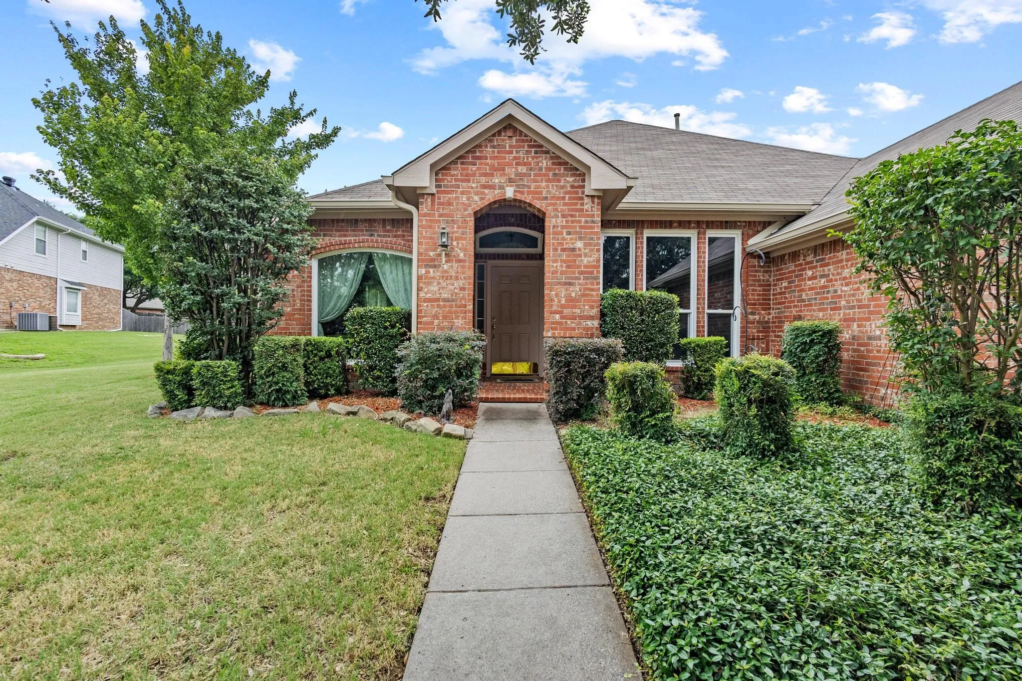 Covered entry and mature landscaping