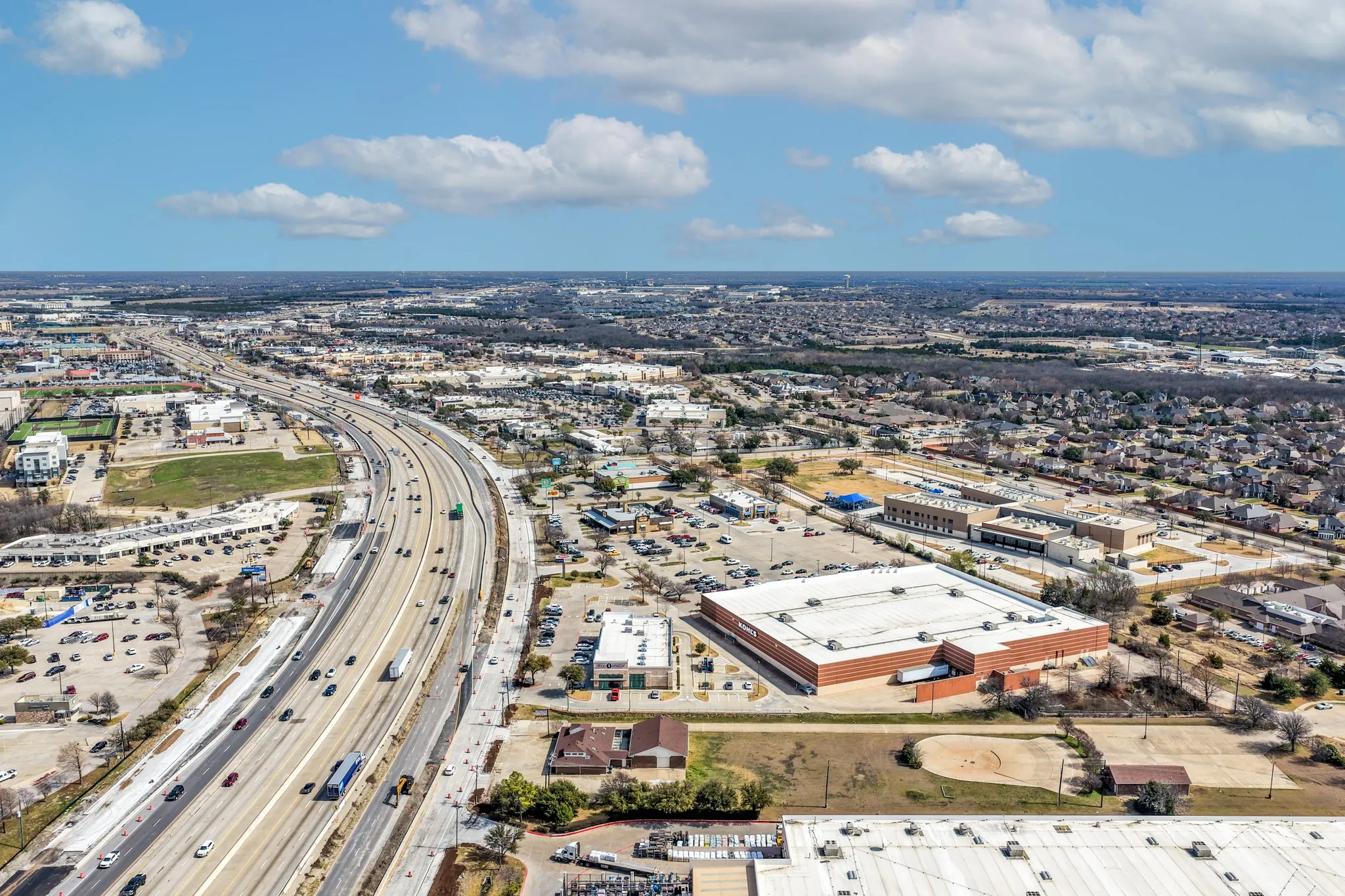 Aerial view of property and surrounding area featuring a highway