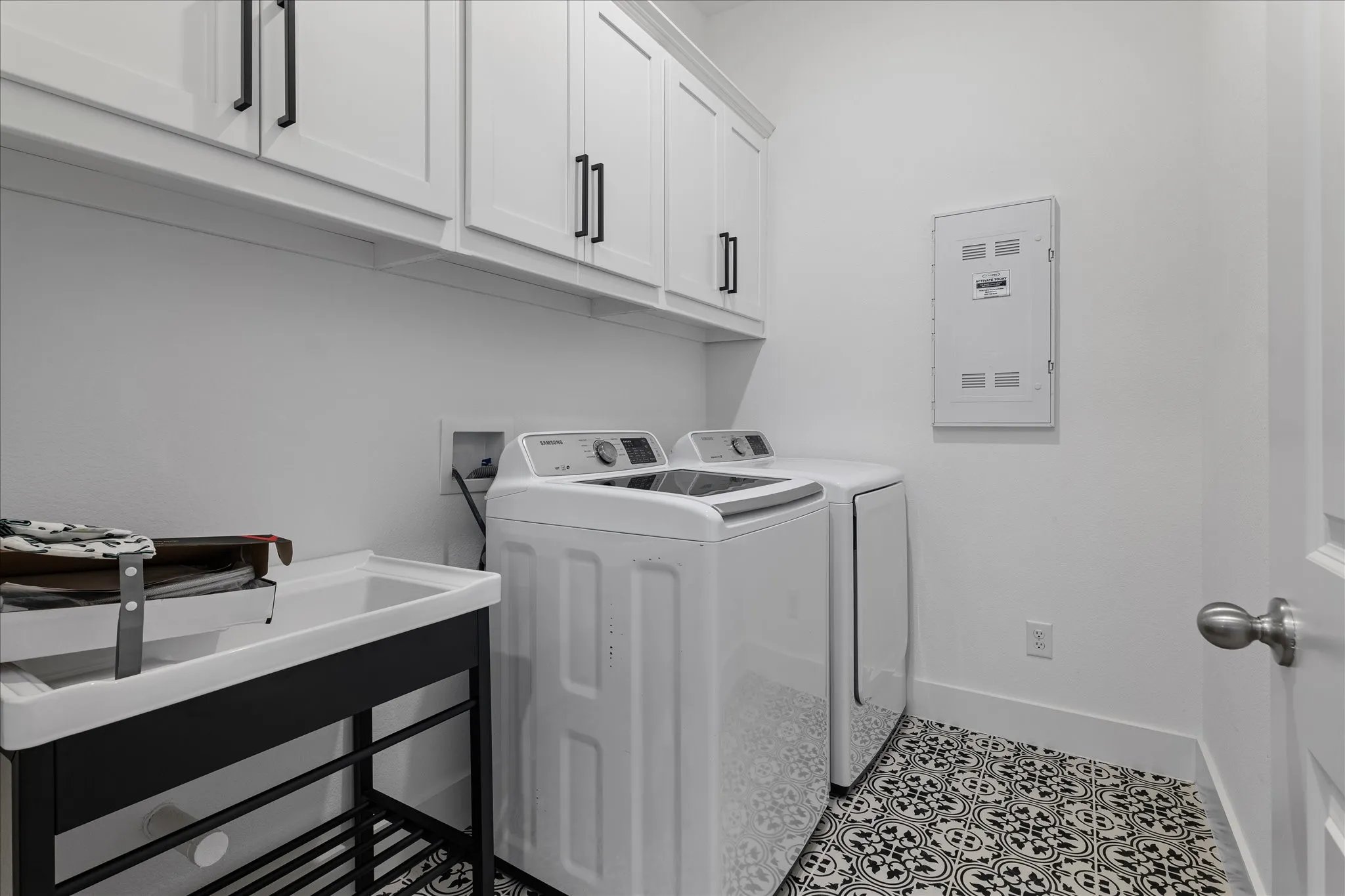 Laundry area with cabinet space, washer and dryer, and light tile patterned floors