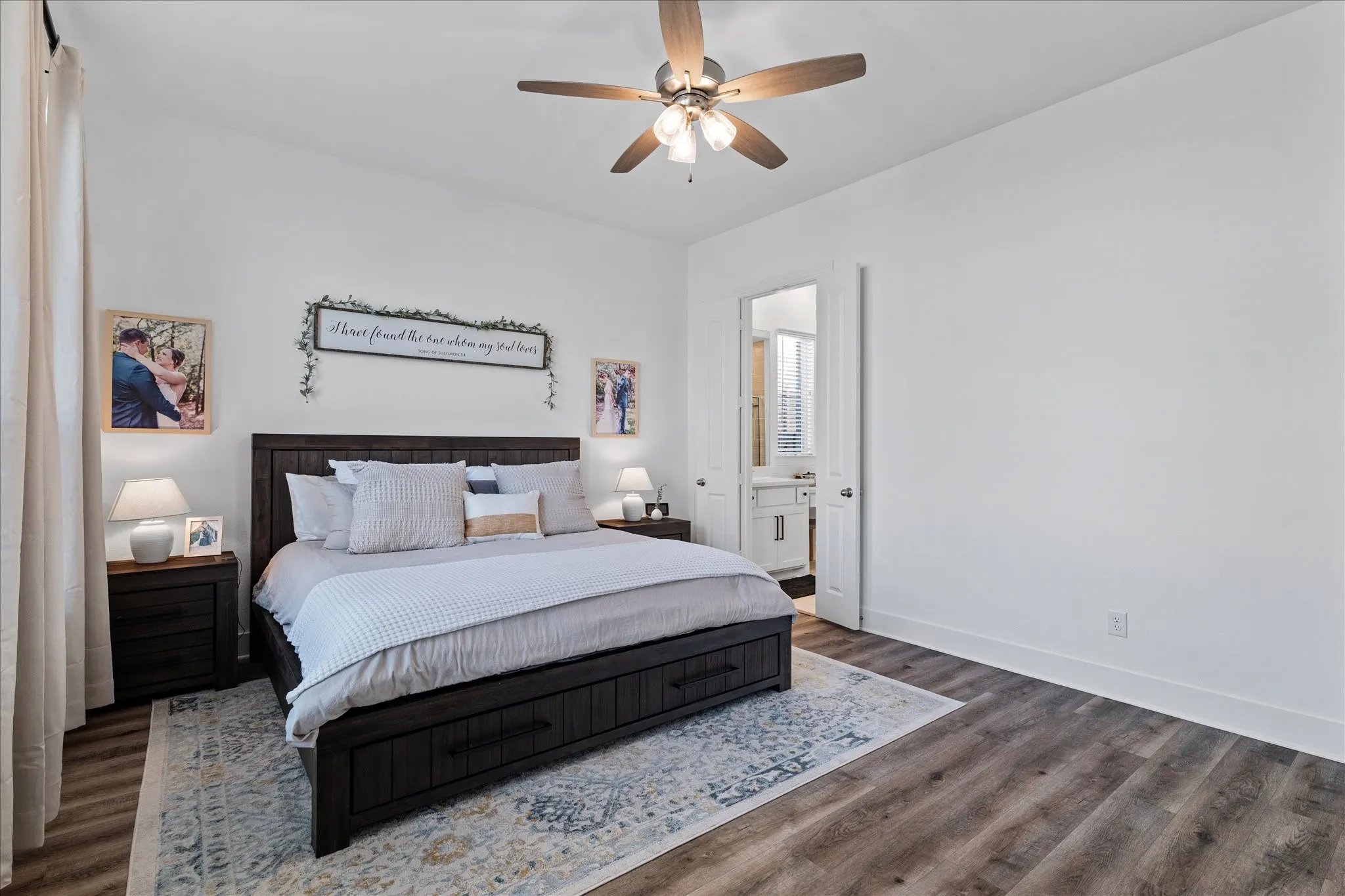 Bedroom with a ceiling fan, dark wood finished floors, and connected bathroom