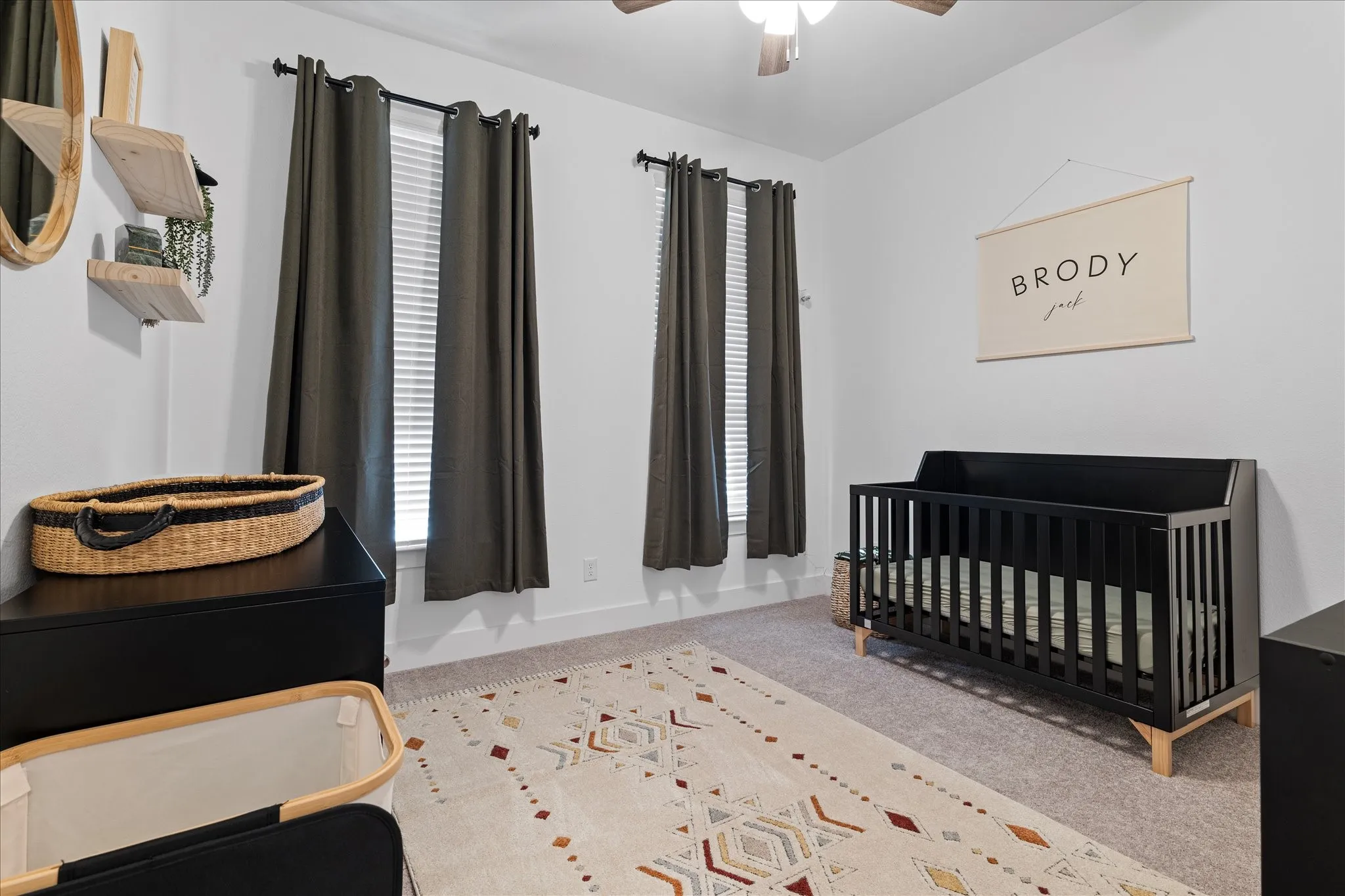 Bedroom featuring a crib, light colored carpet, and ceiling fan