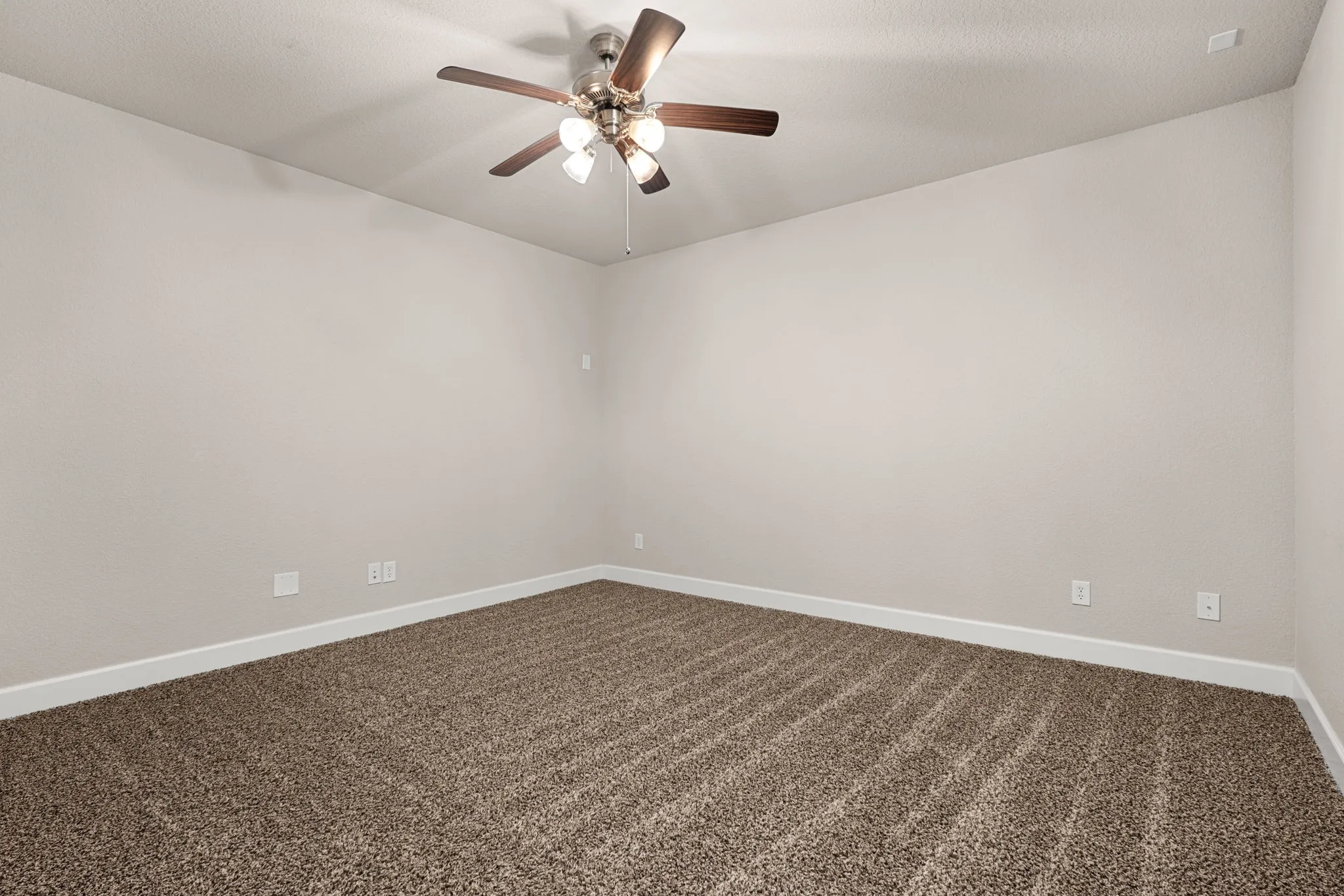 Unfurnished room featuring a ceiling fan and dark carpet