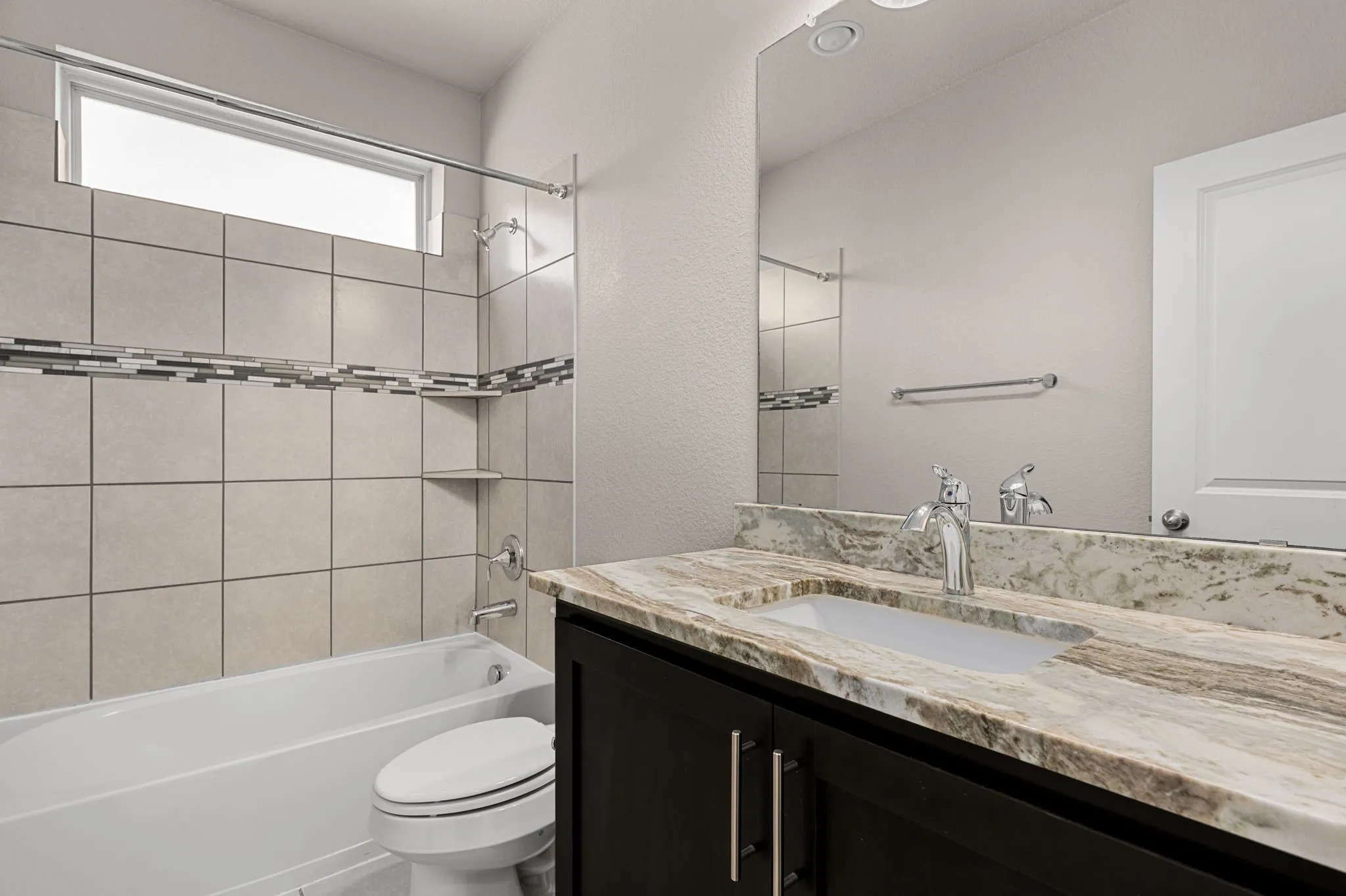 Full bath with vanity, bathtub / shower combination, and a textured wall
